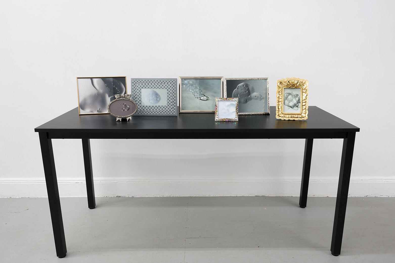Still life, 2024, prints, frames, table, 38 x 63 x 24 in. (96.5 x 160 x 61 cm.)