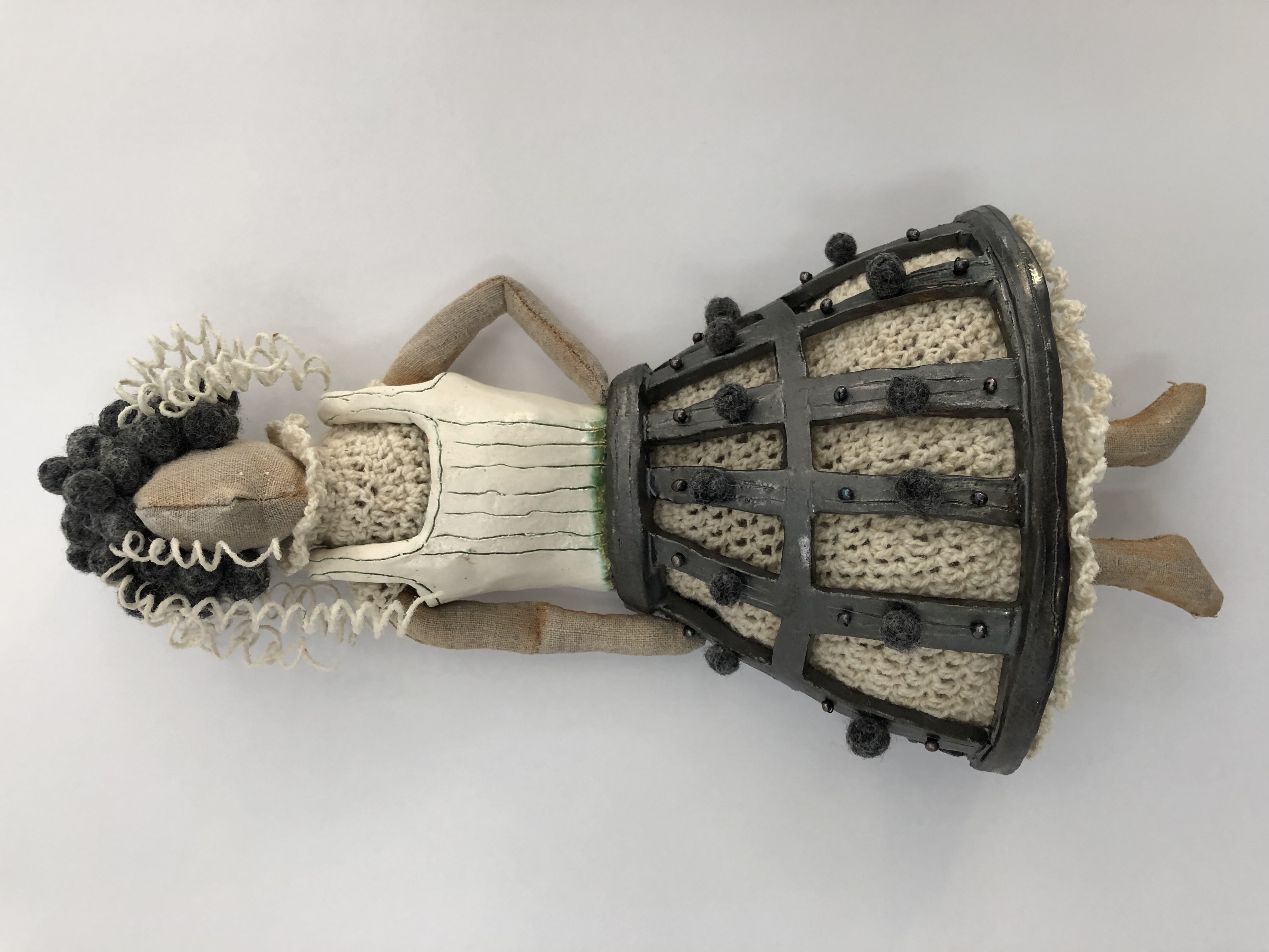 Untitled (steel skirt), at The New Local Gallery → ceramic, crochetted wool yarn, linen fabric, felted wool, black pearl beads