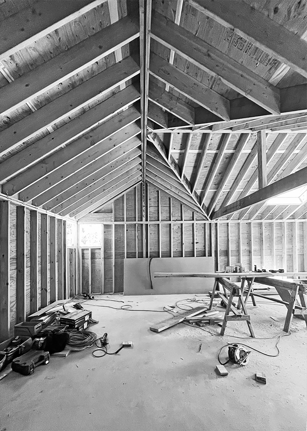 Black and white construction photo showcasing the complex wood framing of the High Bar Pavilion roof structure, highlighting the intersecting vaulted ceilings.
