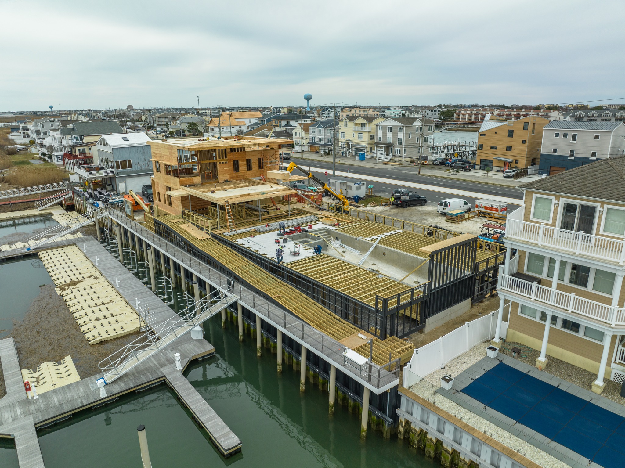 Aerial drone photo of the Brigantine Marina Paddle Club construction, showcasing the building structure, elevated boardwalk, pool area, and surrounding Brigantine landscape.