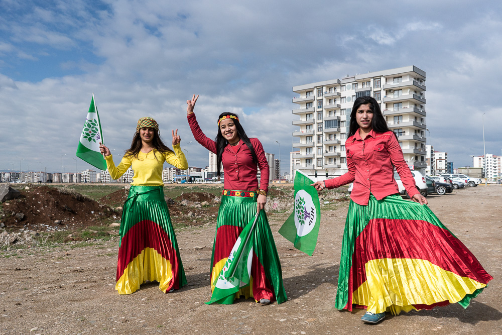 Diyarbakir.  F&ecirc;te de Newroz 2017. Ces jeunes filles se voient refuser l'entr&eacute;e &agrave; la f&ecirc;te par la police parce qu'elles portent les couleurs kurdes. Malgr&eacute; les tensions, la foule est pr&eacute;sente en nombre lors des c&eacute;l&eacute;brations de Newroz &agrave; Diyarbakir c&eacute;l&eacute;brations interdites dans les autres villes). La police interdit les v&ecirc;tements et ch&acirc;les au couleur du Kurdistan, ainsi que tout drapeau d'organisations li&eacute;es au PKK. Plusieurs personnes seront plac&eacute;es en garde &agrave; vue, un homme qui tentait de s'enfuir apr&egrave;s qu'un couteau ait &eacute;t&eacute; d&eacute;couvert sur lui pendant la fouille abattu. La police a &eacute;galement fait retirer un portrait de martyr d&eacute;roul&eacute; pendant la c&eacute;r&eacute;monie mena&ccedil;ant de couper le courant pour mettre fin au rassemblement. Malgr&eacute; tout, les participants ont montr&eacute; leur d&eacute;termination &agrave; faire face au climat de peur instaur&eacute; par Erdogan, et la f&ecirc;te est devenu un meeting pour le non au referendum du 16 avril qui doit accorder les pleins pouvoirs au despote.