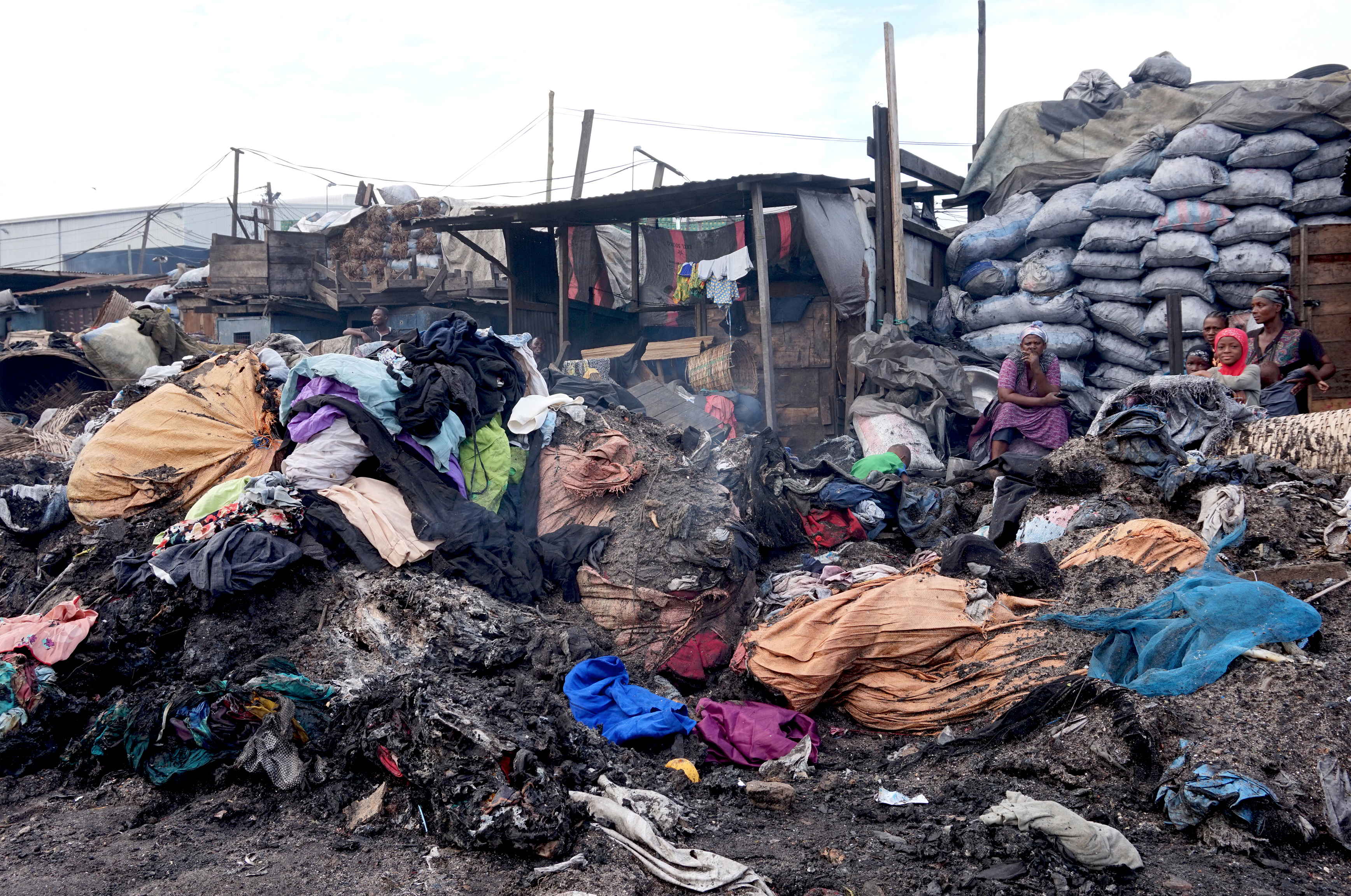 A house on, or in between left over bales of lower quality material that end up as landfill outside Kantamanto, Accra, 10.07.2018