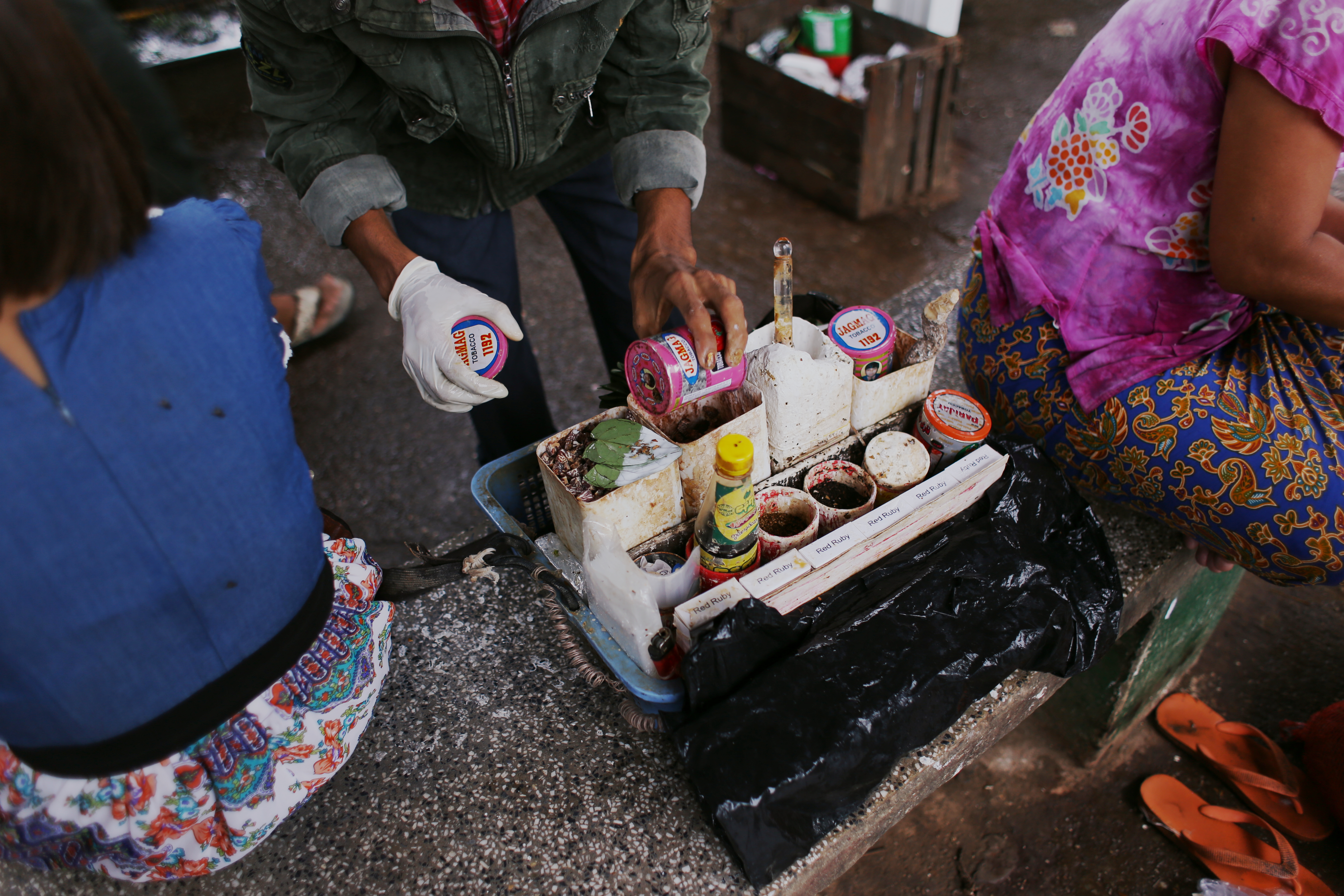 A station vendor prepares areca nuts and betel leaves for sale. Extremely popular in Myanmar, the betel leaves are painted with calcium hydroxide and wrapped around an areca nut. Tobacco and various spices are also sometimes added now for flavour. Betel leaves are known for their medicinal and mild stimulant properties; chewers can be seen sporting vermillion-stained grins.