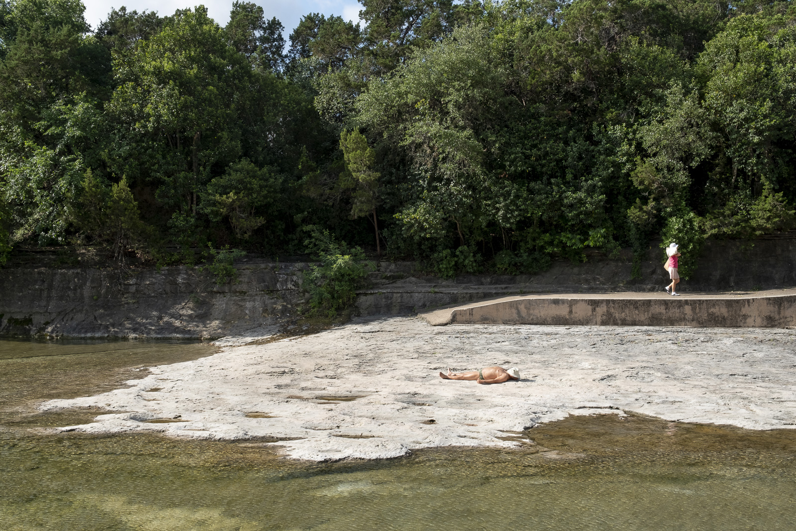 A sun-seeker and bather at Barton Springs in Austin.