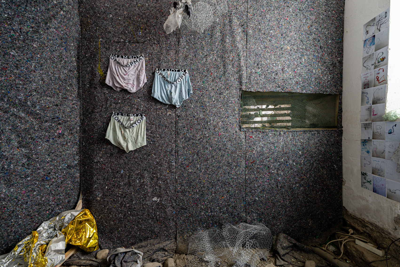 Bild 4: Blick auf die linke Wand im Inneren des begehbaren Staubsaugers. Diese Wand ist ebenfalls mit Teppichflie&szlig; verkleidet. An der Wand h&auml;ngen drei Boxershorts, mit Staubsauger-Zeichnungen darauf.