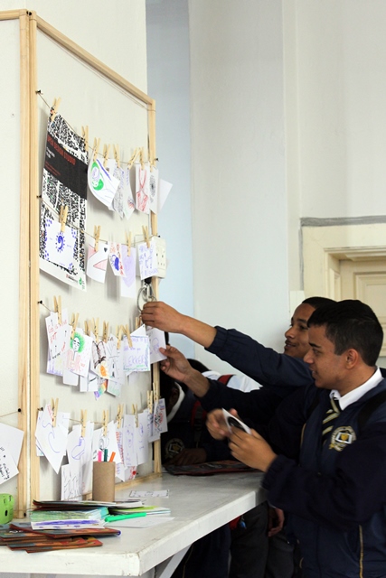 Youth pinning up their ideas around what home represents for them