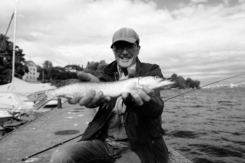 Frischer Morgenfang: Stolz pr&auml;sentiert der Hobbyfischer seinen Fang und geniesst die Ruhe des fr&uuml;hen Morgens am See.