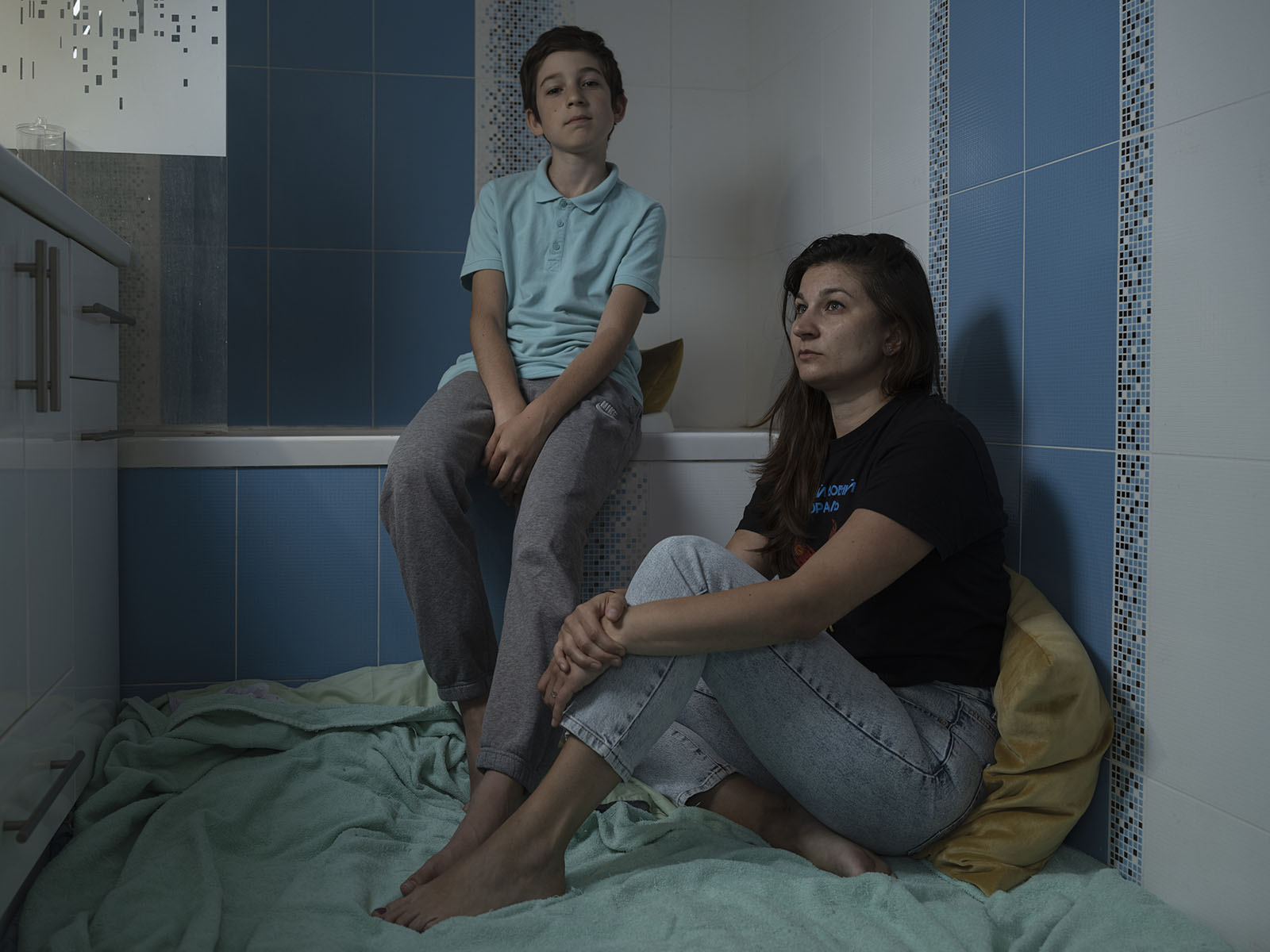 Viktoriia Pysmenna with her son Mark in the bathroom of their apartment in Kyiv where they typically shelter during the night air raids.