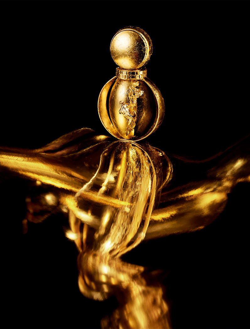 KMA photographer Isabelle Bonjean shoots a close up photograph of a bright gold perfume bottle for Faux Q Magazine 