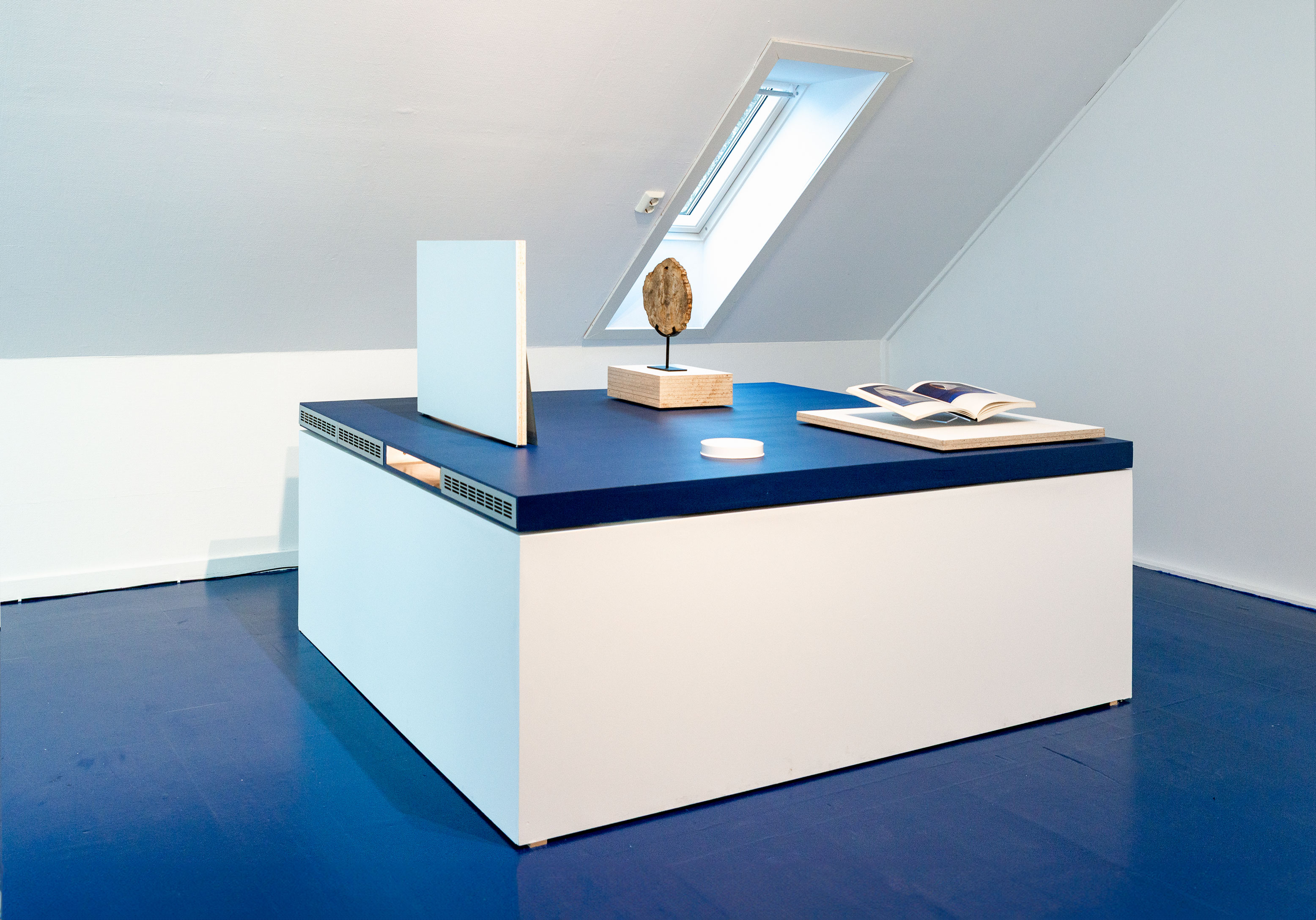 The Crypt (2025) &ndash; Chipboard, paint, tree root fossil, printed image of Apollo (The Chatsworth Head - British Museum), book: &lsquo;Naum Gabo: Sixty Years of Constructivism,&rsquo; wheat sheaf, mirror, lights, poster from the exhibition Krypten by Markku Kosonen at Hordaland Kunstsenter in 1989 &ndash; dimensions variable.