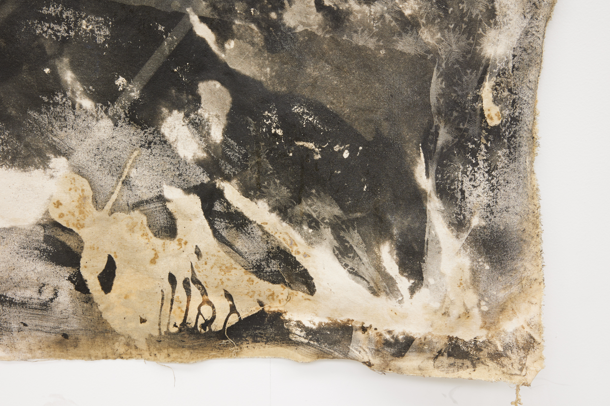 detail of corner of artwork, showing material yellowing and white marks disappearing into black background