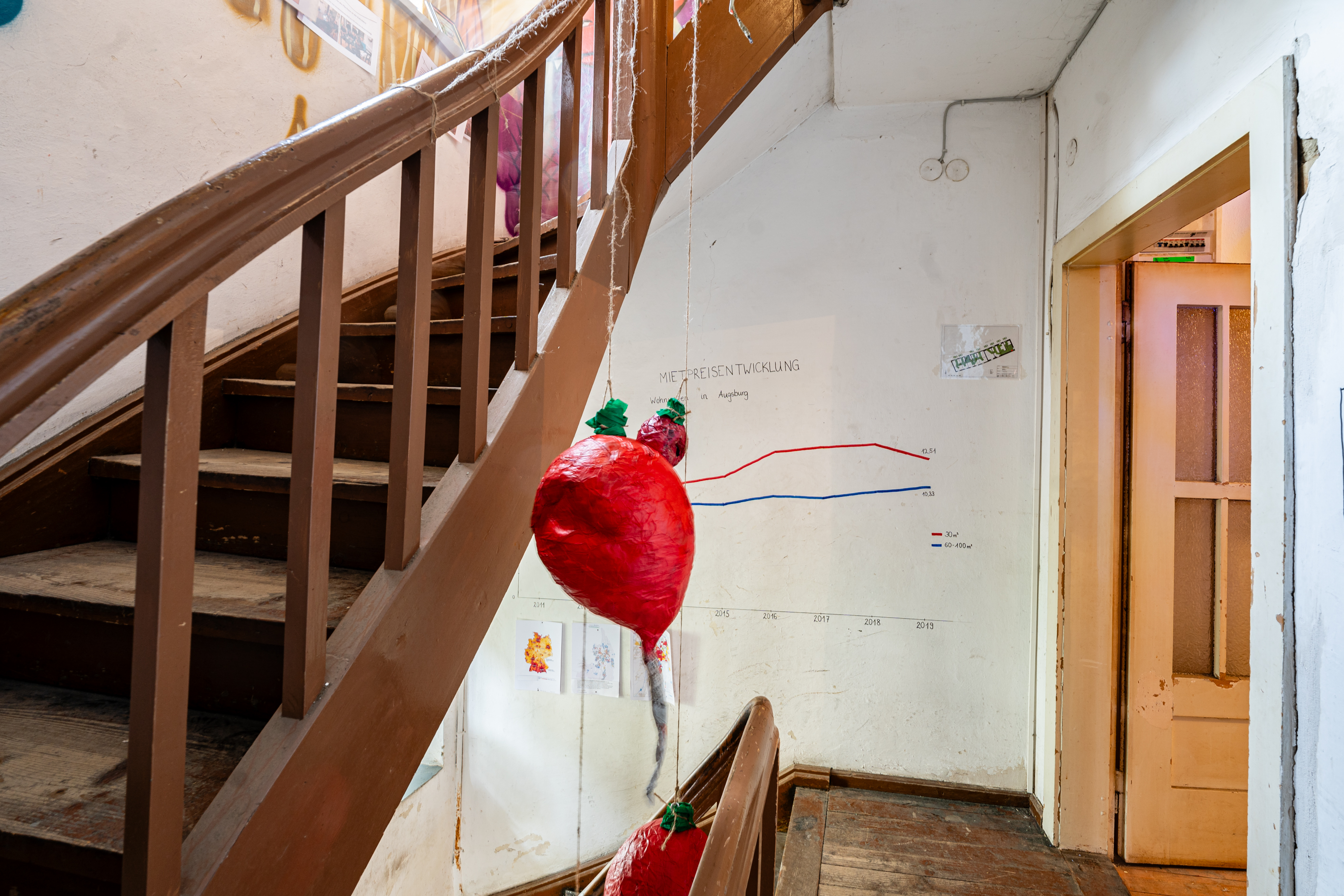 Bild 3 zu Hoch hinaus?!: Eine selbst gemalte Infografik an der Wand des Treppenhauses gibt &Uuml;berblick &uuml;ber die Mietpreisentwicklung Augsburgs der letzten 10 Jahre.