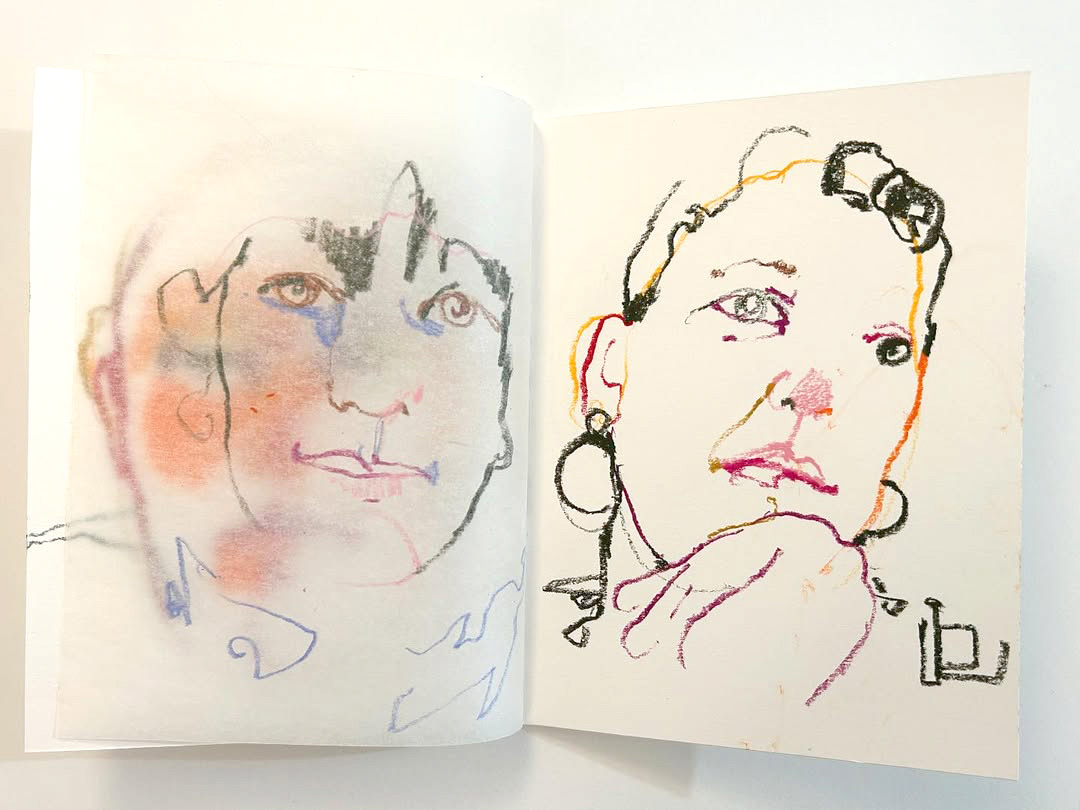 Two faces drawn in a home-made sketchbook.