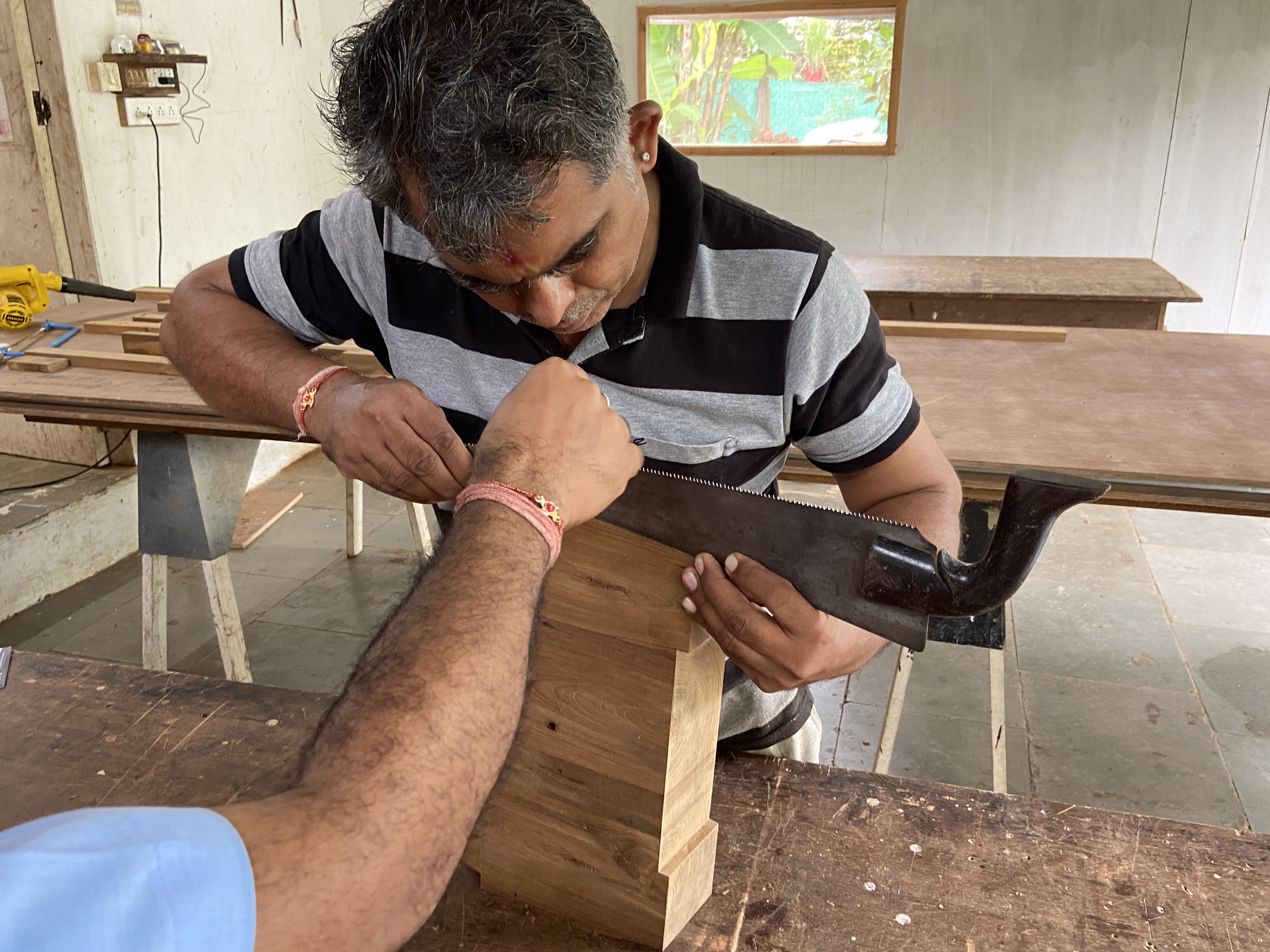 Momtaram ji testing out different curvatures for the legs using the edge of a saw.