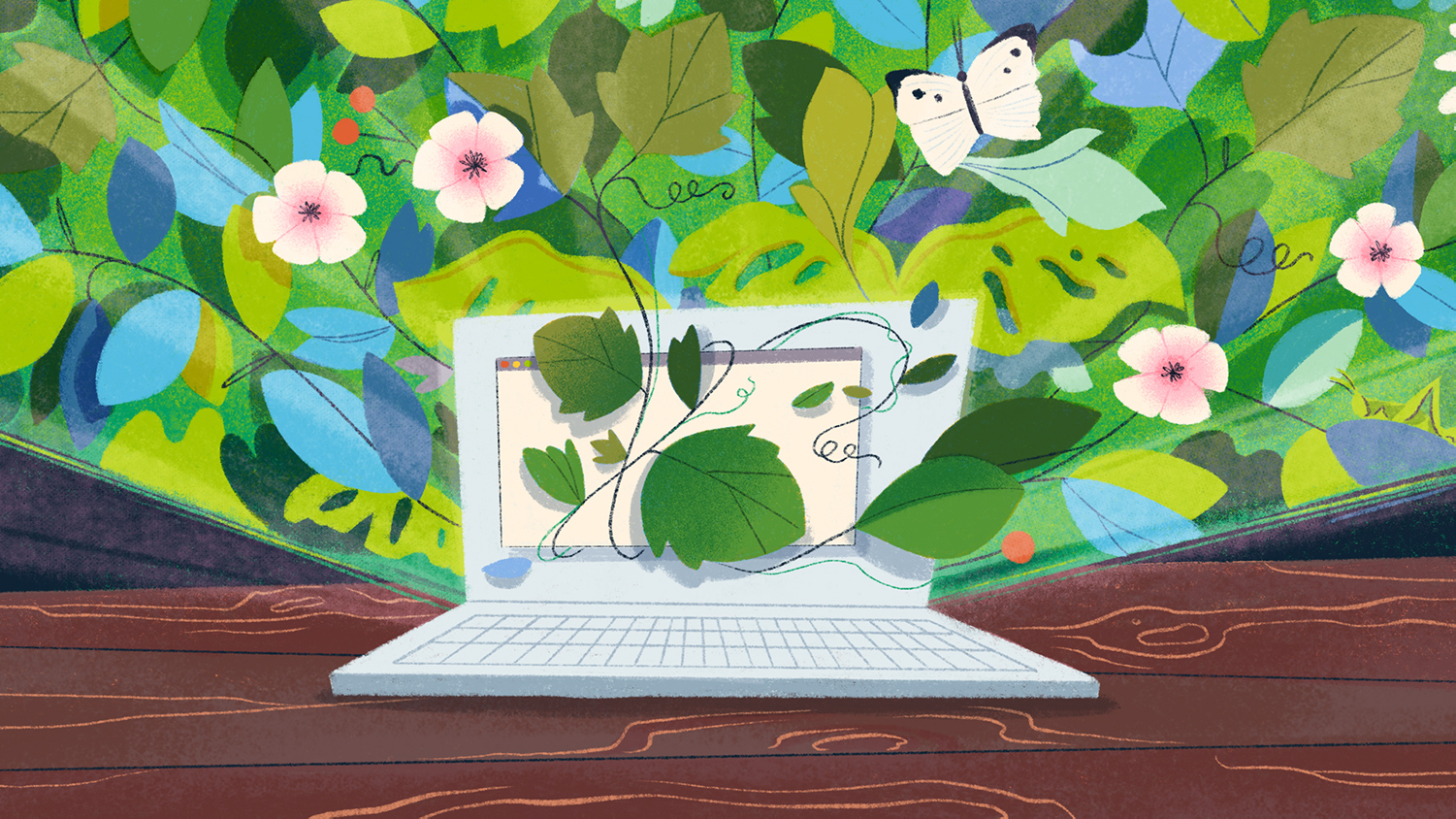 A computer on a table with flowers coming out of it.