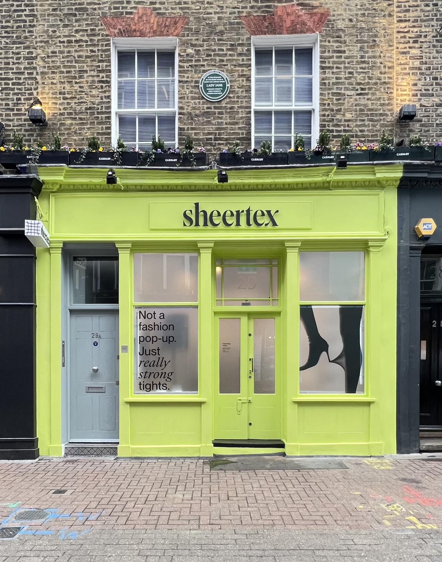 Exterior of Sheertex London pop-up store painted lime green with brand logo and tights campaign slogan.
