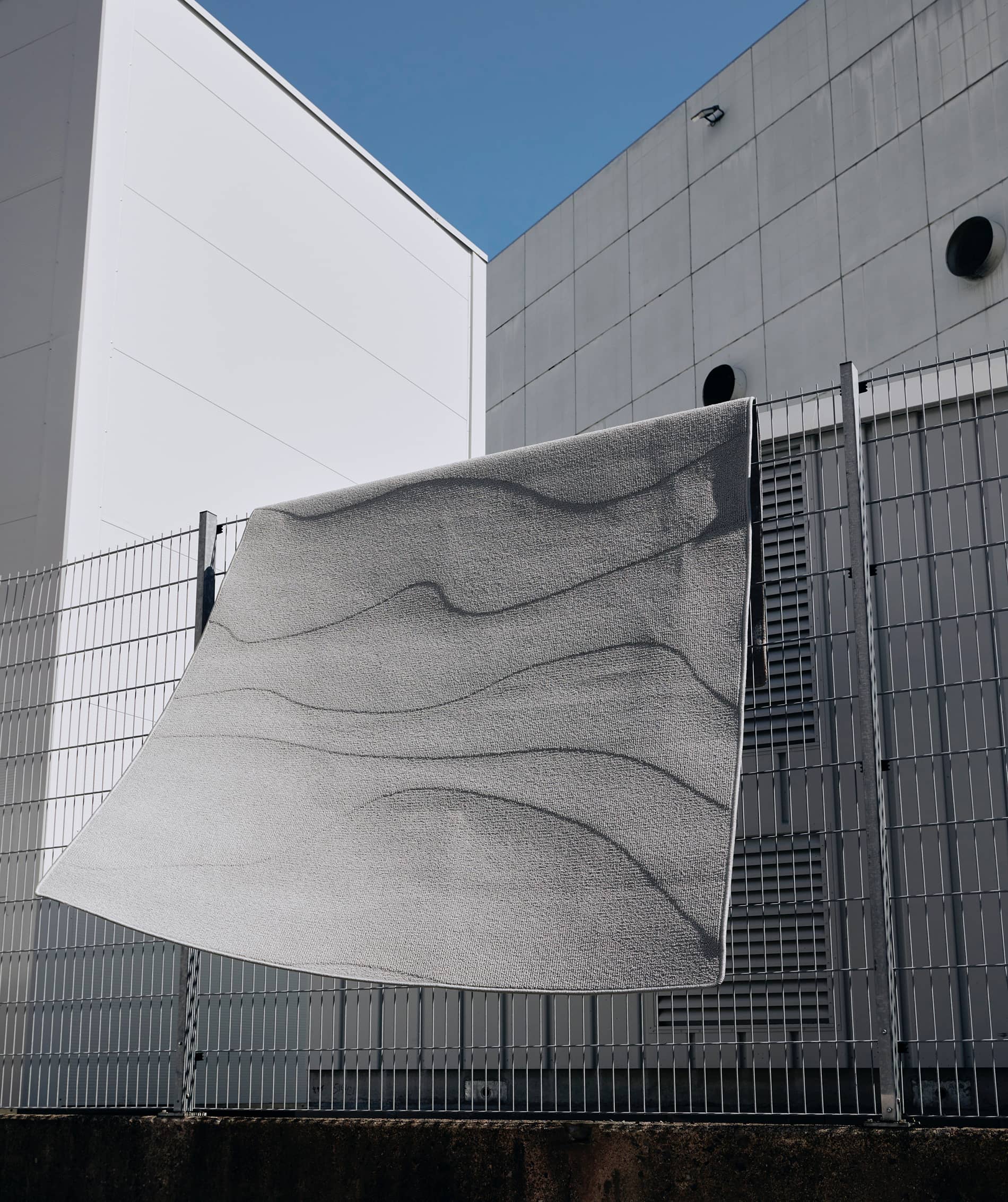 A NEW WAVE FOR EGEInspired by the rough and untouched landscape of the Danish west coast, A New Wave strives towards tactility on a functional and sensual level that allows you to feel the patterns of the sand, the strict lines of the grass dunes and the rhythm of the waves washing in. Multi levels in the carpet construction form the sculptural patterns while the colour palette reflects the dry and delicate tones of the seaside.The collection is crafted from regenerated and regenerable yarns based on abandoned fishing nets, used carpets and other industrial waste.Designed in collaboration with Laura BildeGo to product page →