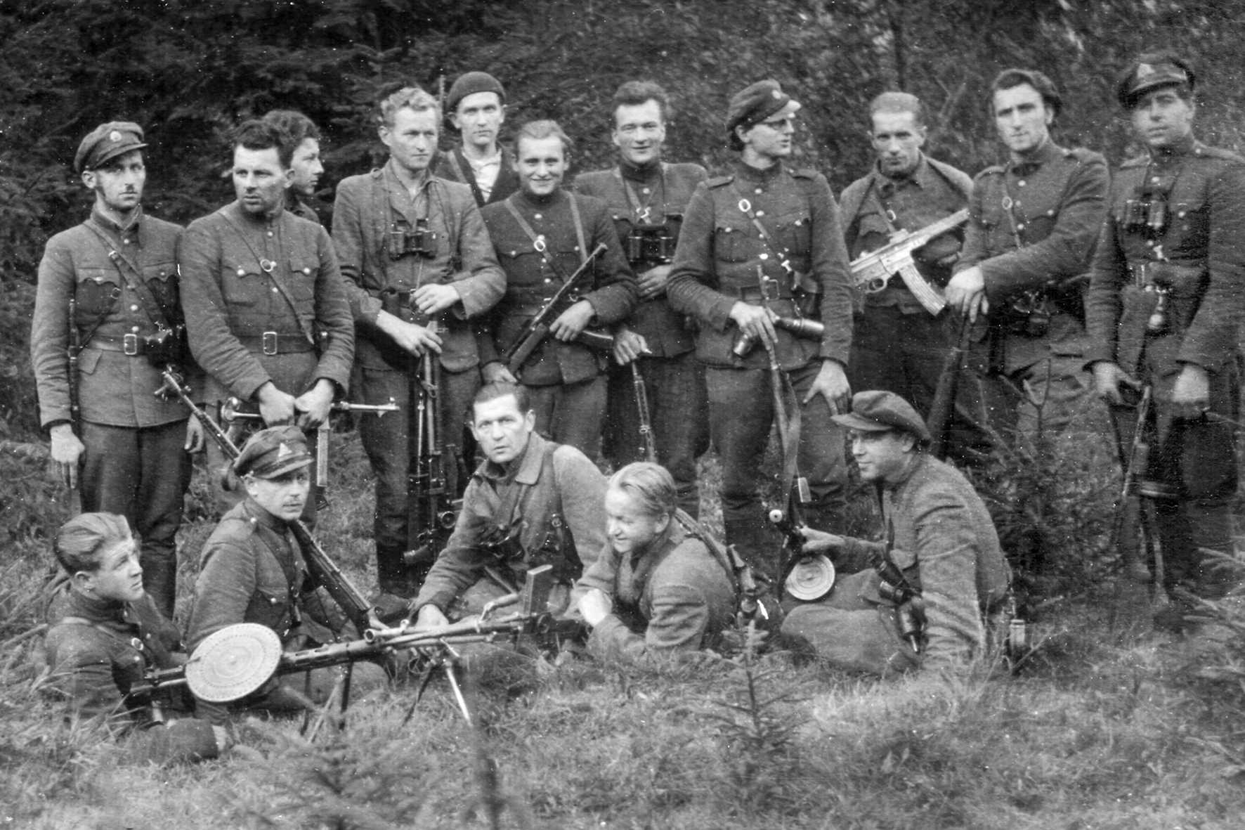 Jungtinės Kęstučio apyg. vadovybė ir ją saugantys partizanai. Guli ir sėdi (iš kairės): Vladas Pečkauskas, Albertas Norkus, Jonas Žemaitis, Pranas Strainys, Kazimieras Ruibys; stovi (iš kairės): Steponas Venckaitis, Mečys Orlingis, Jonas Nuobaras, Aleksas Jurkūnas, Aleksas Jucius, Stasys Šneideris, Antanas Seneckas, Antanas Liesis, Petras Bartkus, Vytautas Gužas, Česlovas Remeikis. 1947–1948 m. (RKLKA)