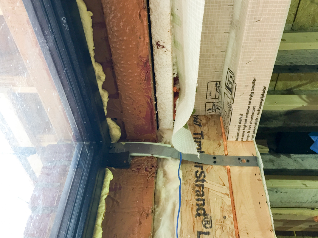 Insulating and air sealing at new windows during construction