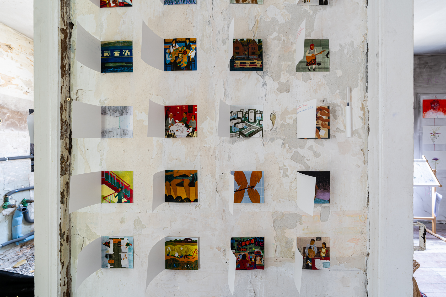 Bild 2 zu die Erinnerung an...: Frontale Ansicht auf 16 der aufgeklappten Illustrationen.