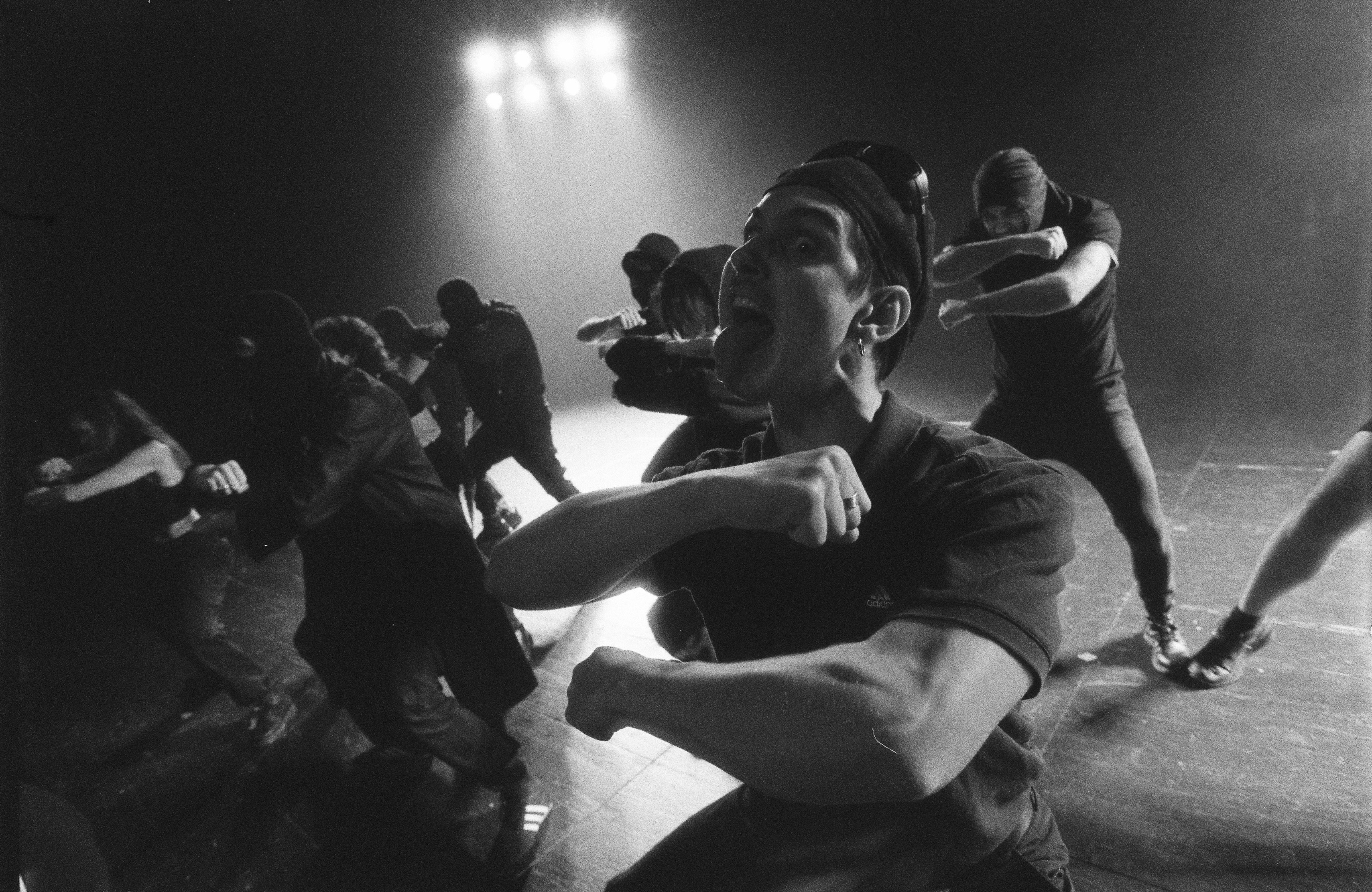 Black and White Picture of a Man Showing Tongue in Haka Formation