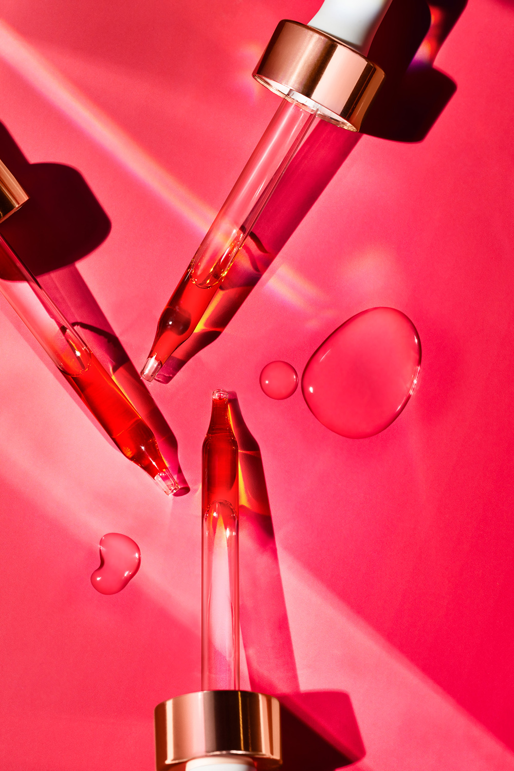 KMA stylist Sara Wacksman designs set for a texture photo of silky red serum drizzled on a pink background for Josie Maran