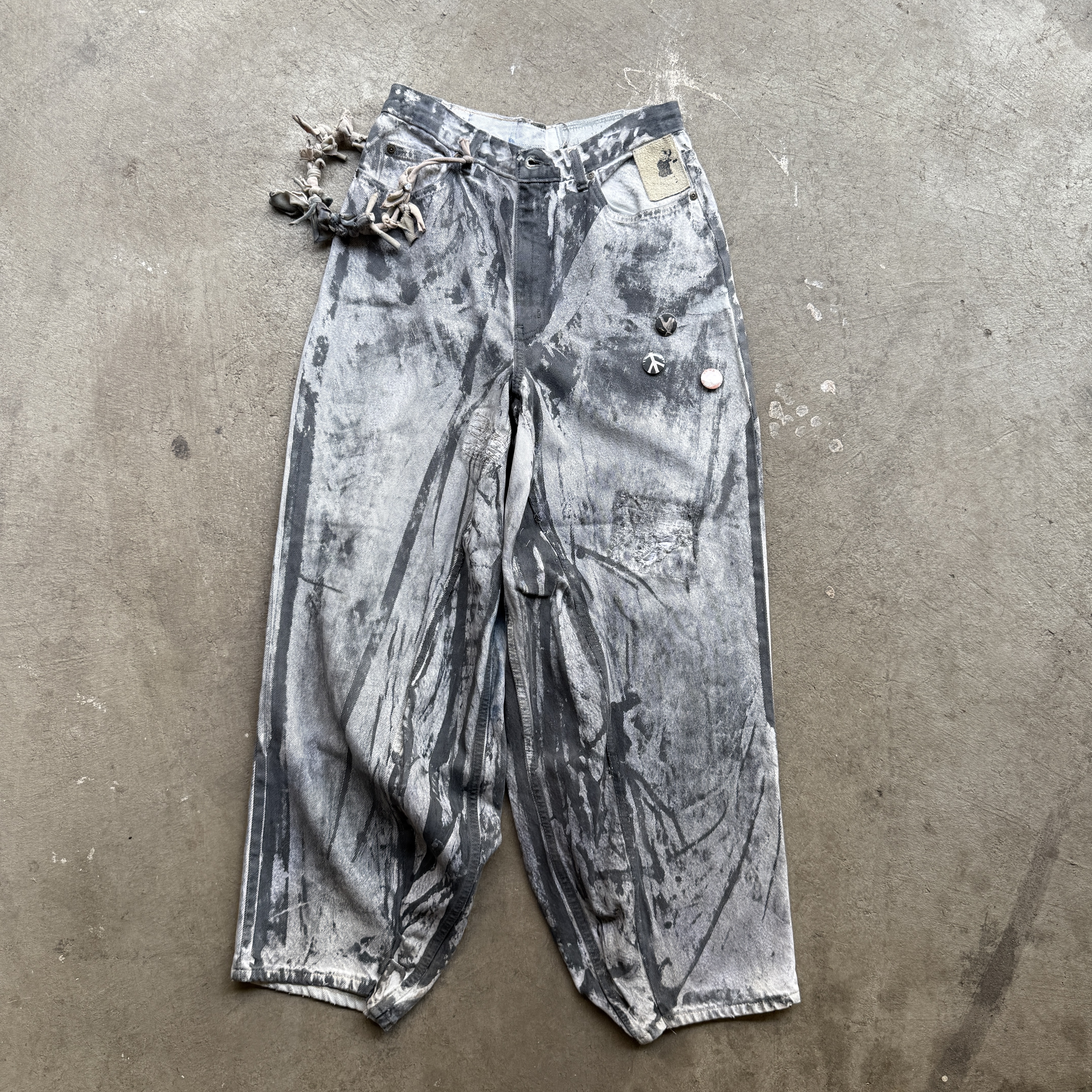 Reclaimed vintage surplus denim allover printed with copper, aluminum, iron & textile dye. Tailored to give a straight/wide fit. Fitted with dyed scrap chain, leather patches, and custom buttons