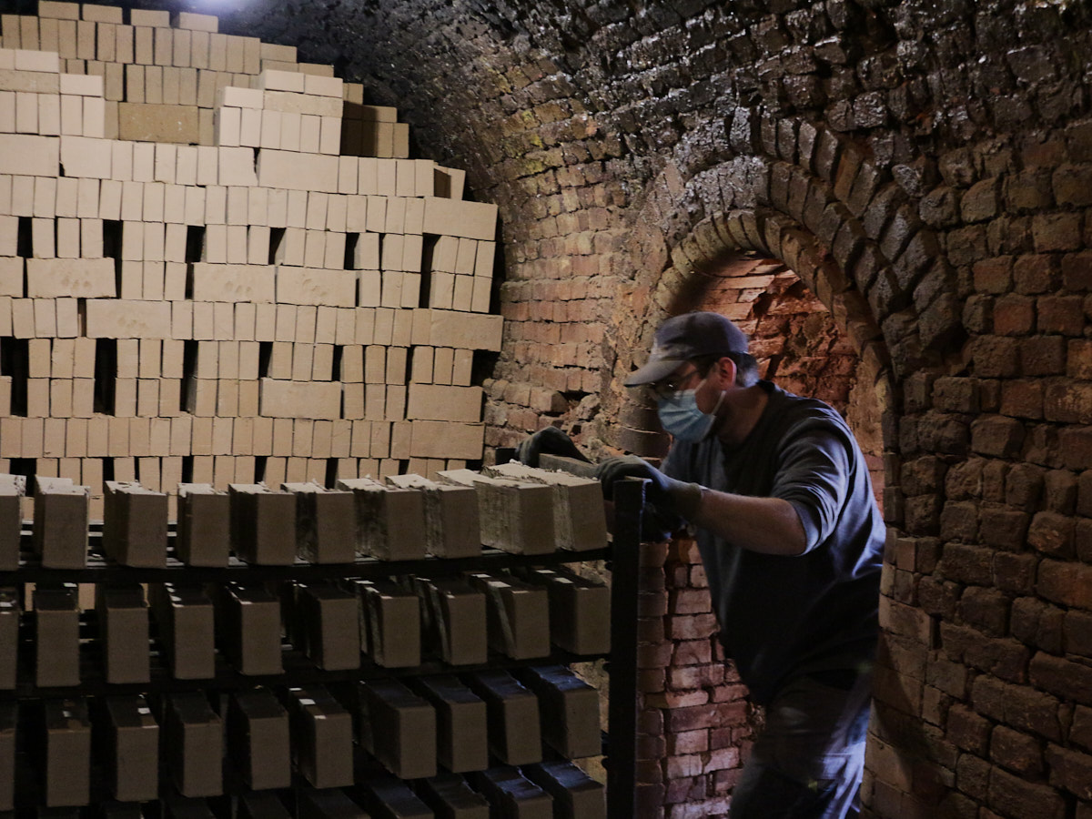  Les briques crues sont enfournées, amenées par chariot et disposées manuellement. 