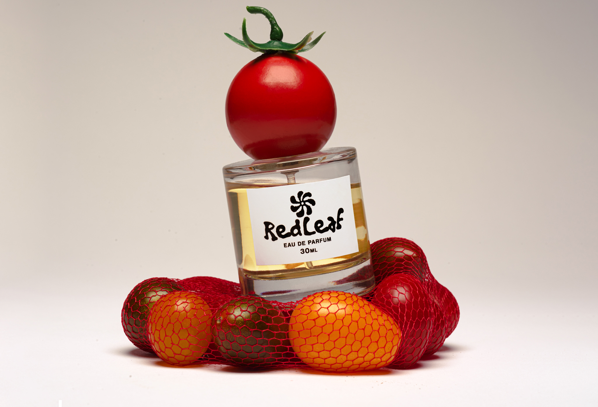 Tomato perfume on top of a net of tomatoes