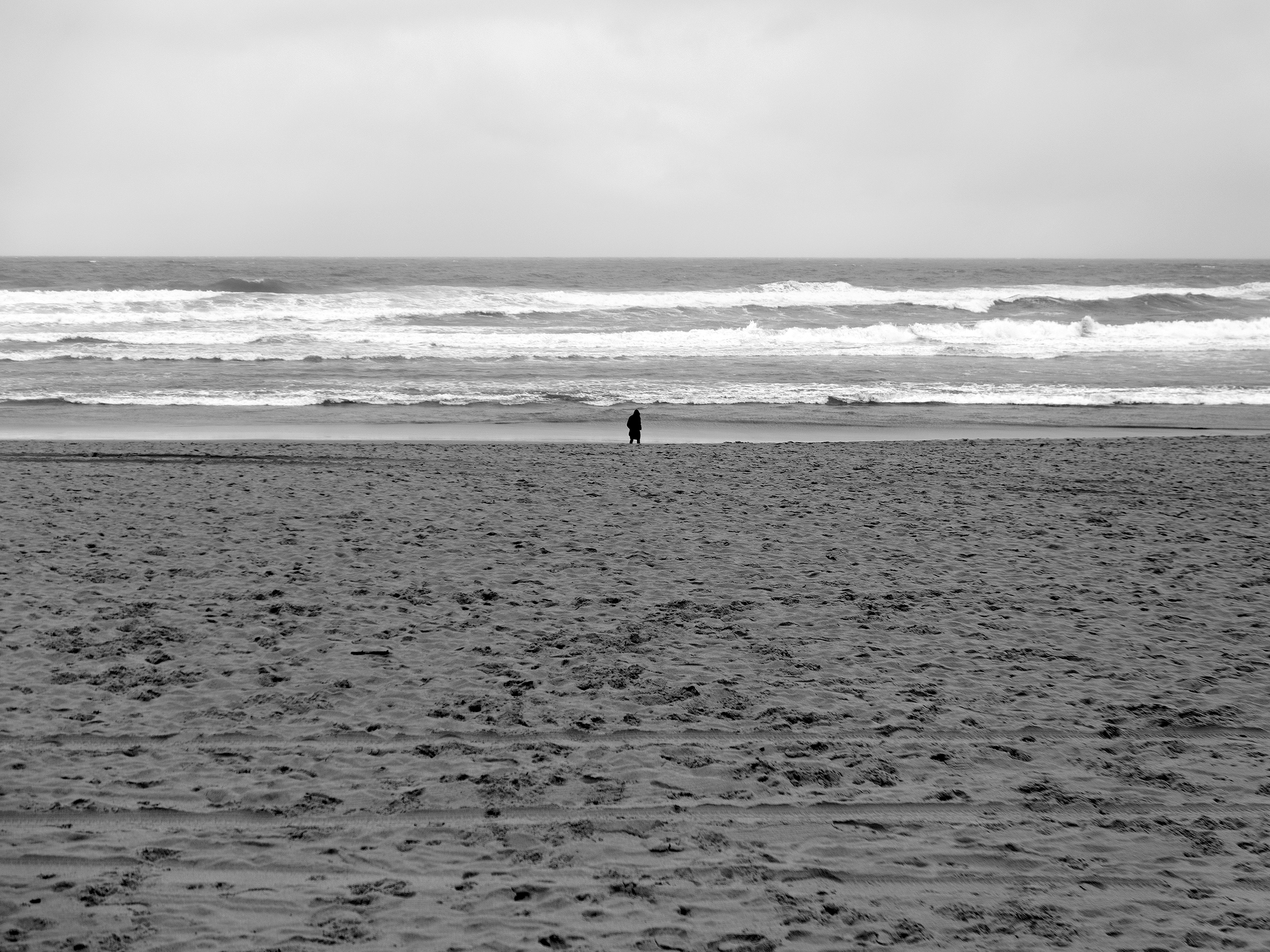 Walker on the beach in a rainy day Donostia, Spain, 2023photography, bw, single