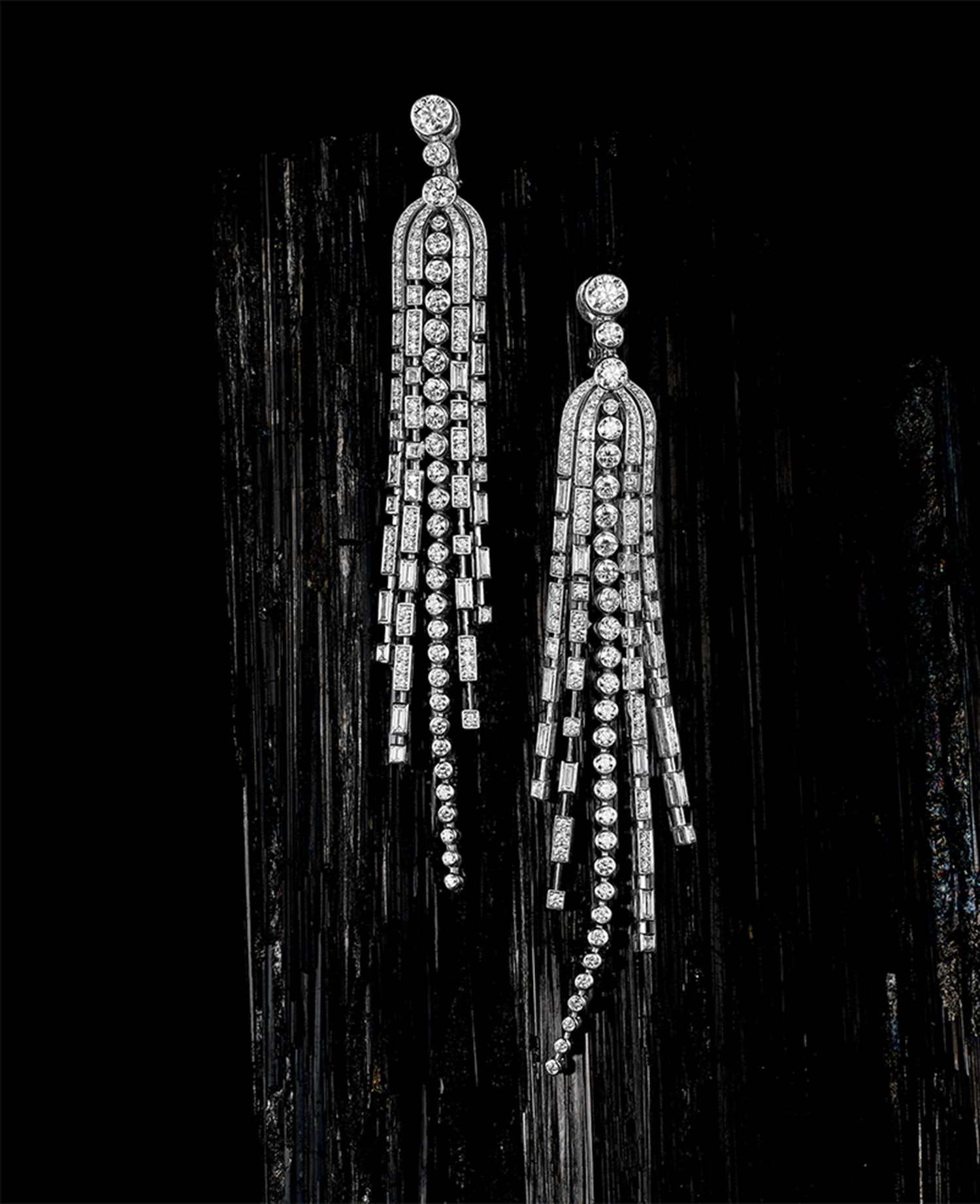 KMA stylist Sara Wacksman designs set for a photo of dangly diamond earrings with black charcoal in the background 