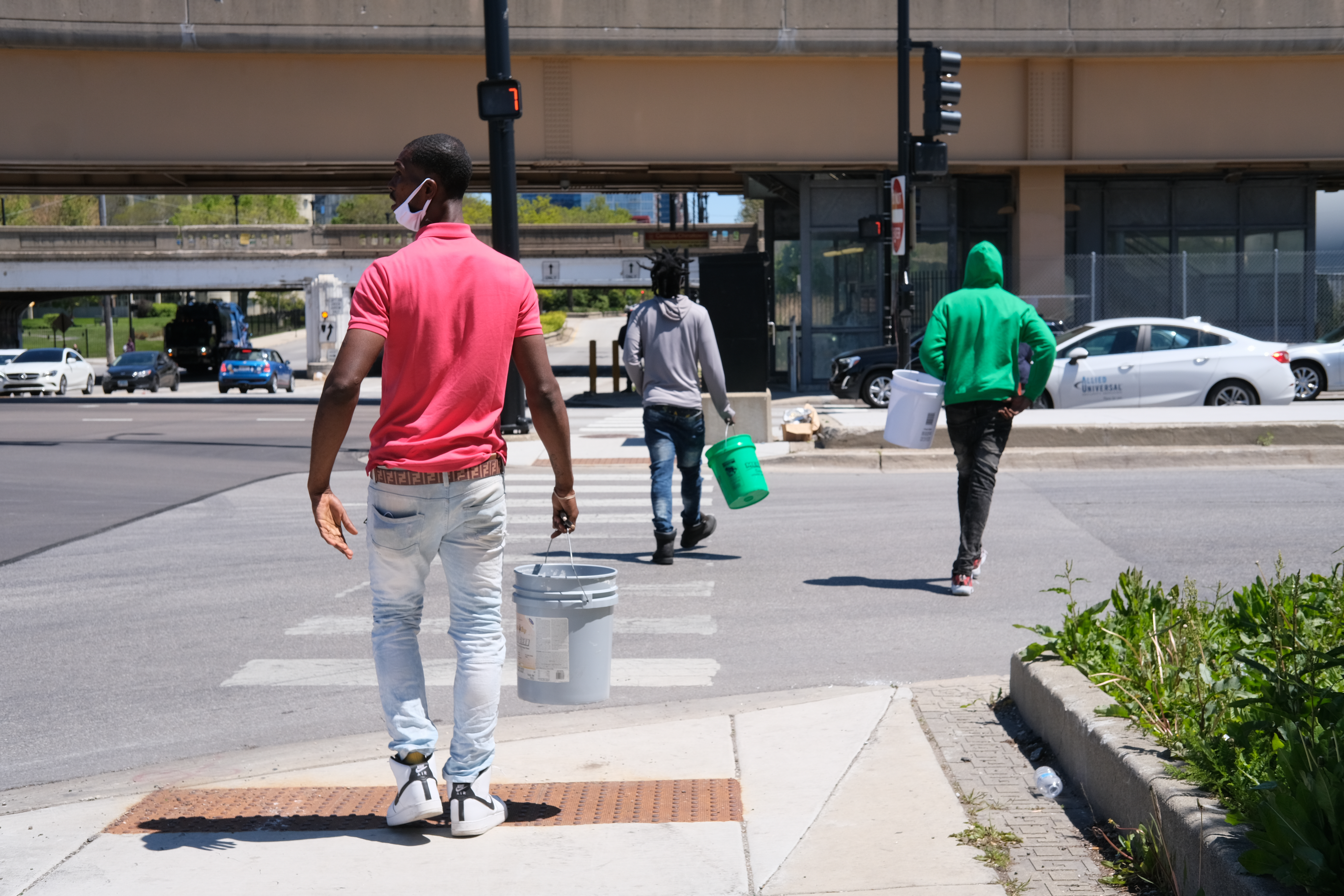 Edward (left), Courvoisier (middle), and Hashema (right) walk to their favorite traffic light in Chinatown to beat their buckets. Chicago, IL.