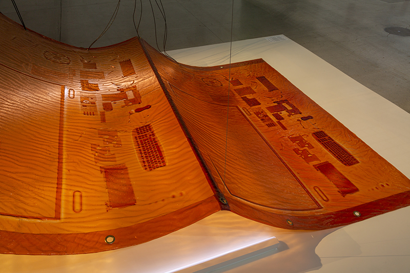 Brown-orange bioplastic material with irregular patterning on it.