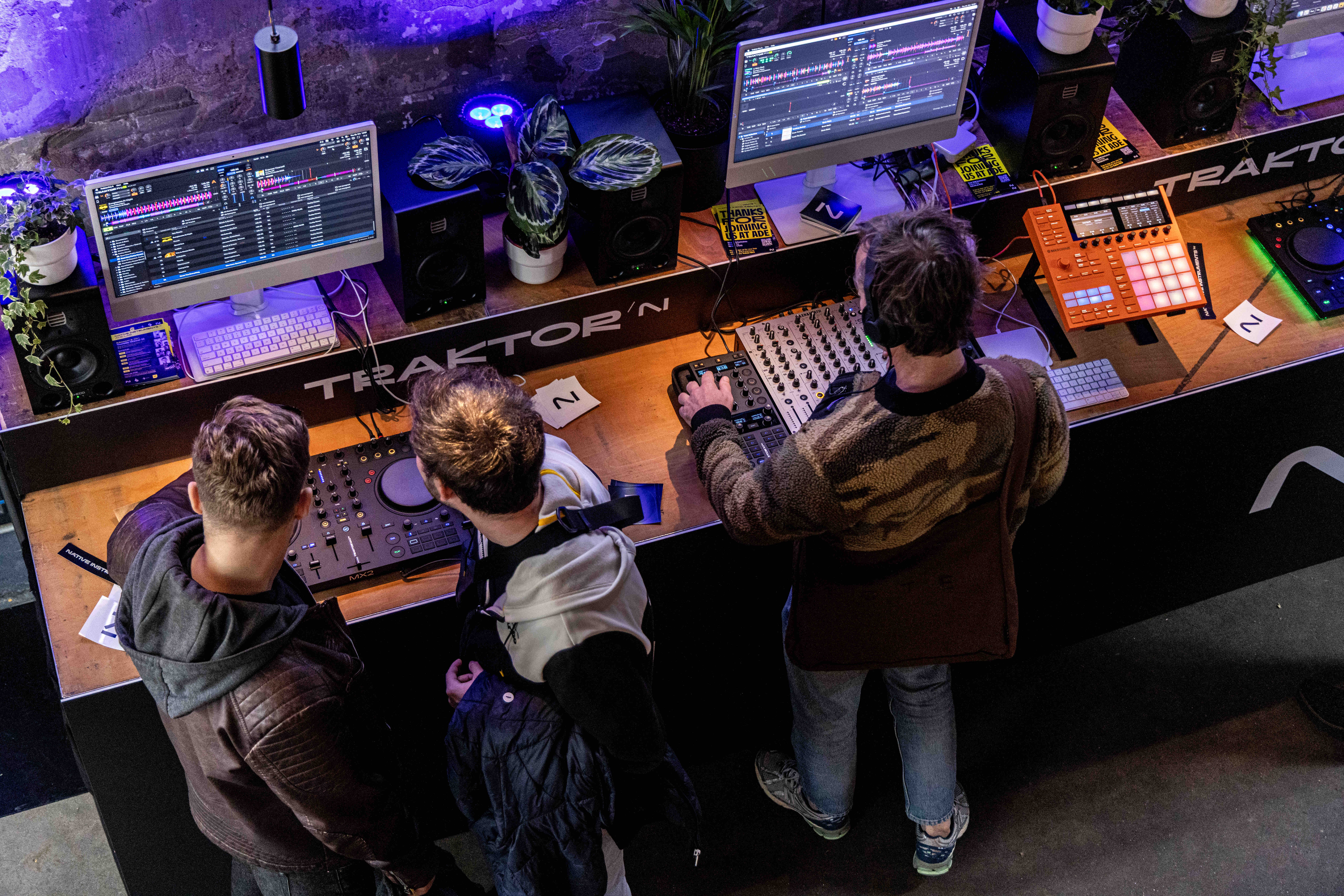 Attendees exploring Traktor software and capturing the moment during the Native Instruments activation at ADE 2025.