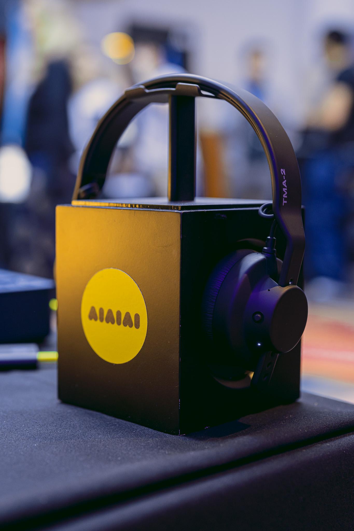 AIAIAI headphones displayed at AVA London 2025, showcasing the TMA-2 model on a branded black and yellow stand.
