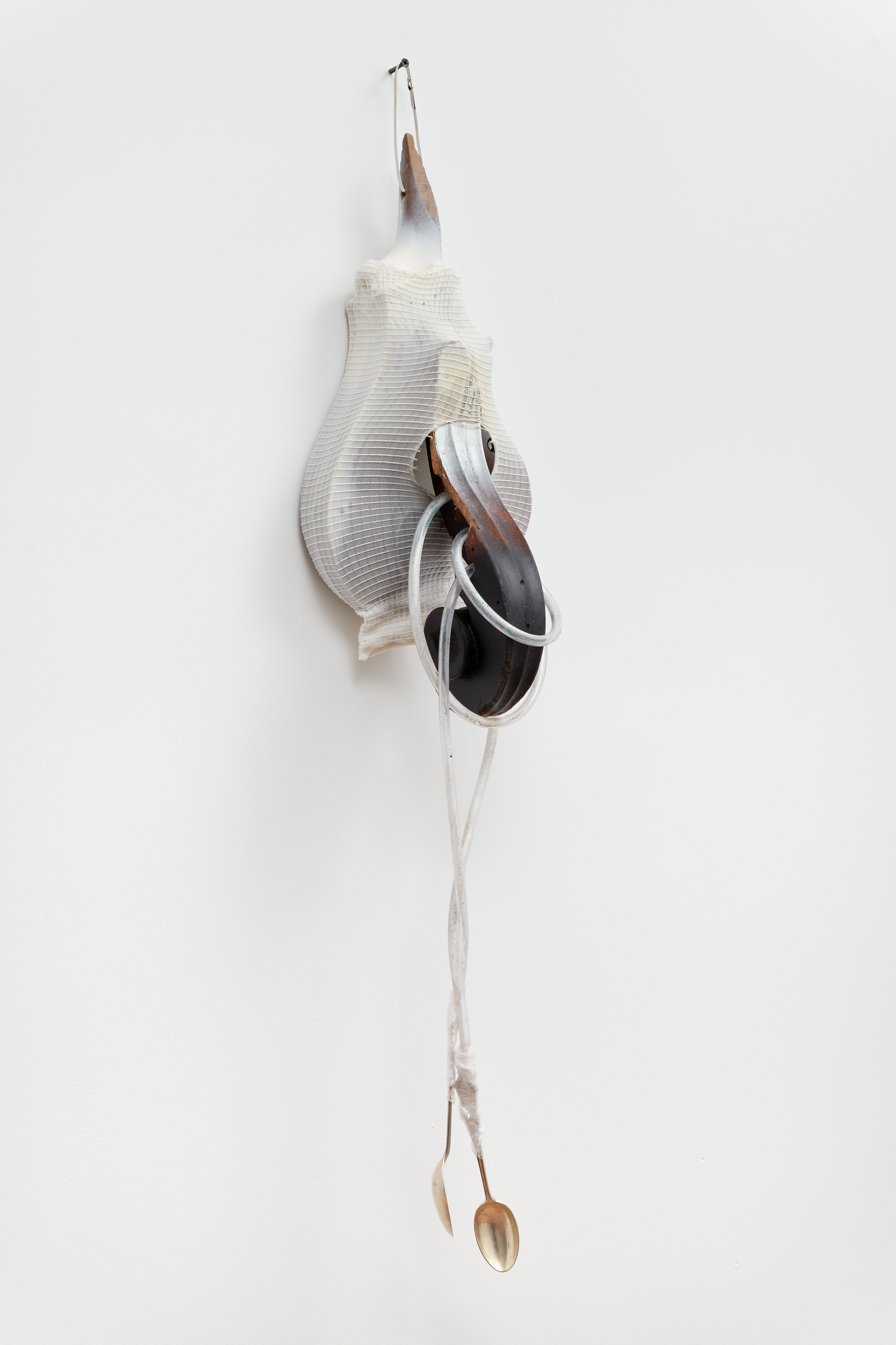 Chasm,  2023, Cello scrolls, PVC pipe, silver spoons, cellophane, elasticated stockinette, spray paint.  23 x 94 x 25cm