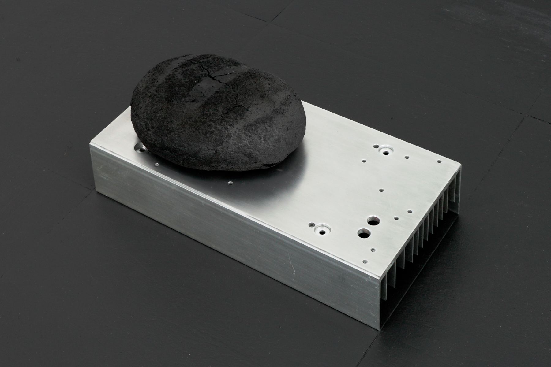 Tectonic attainder, 2018, pyrolized bread, aluminum heat sink, 6 x 12 x 6 in. (15 x 30 x 15 cm)