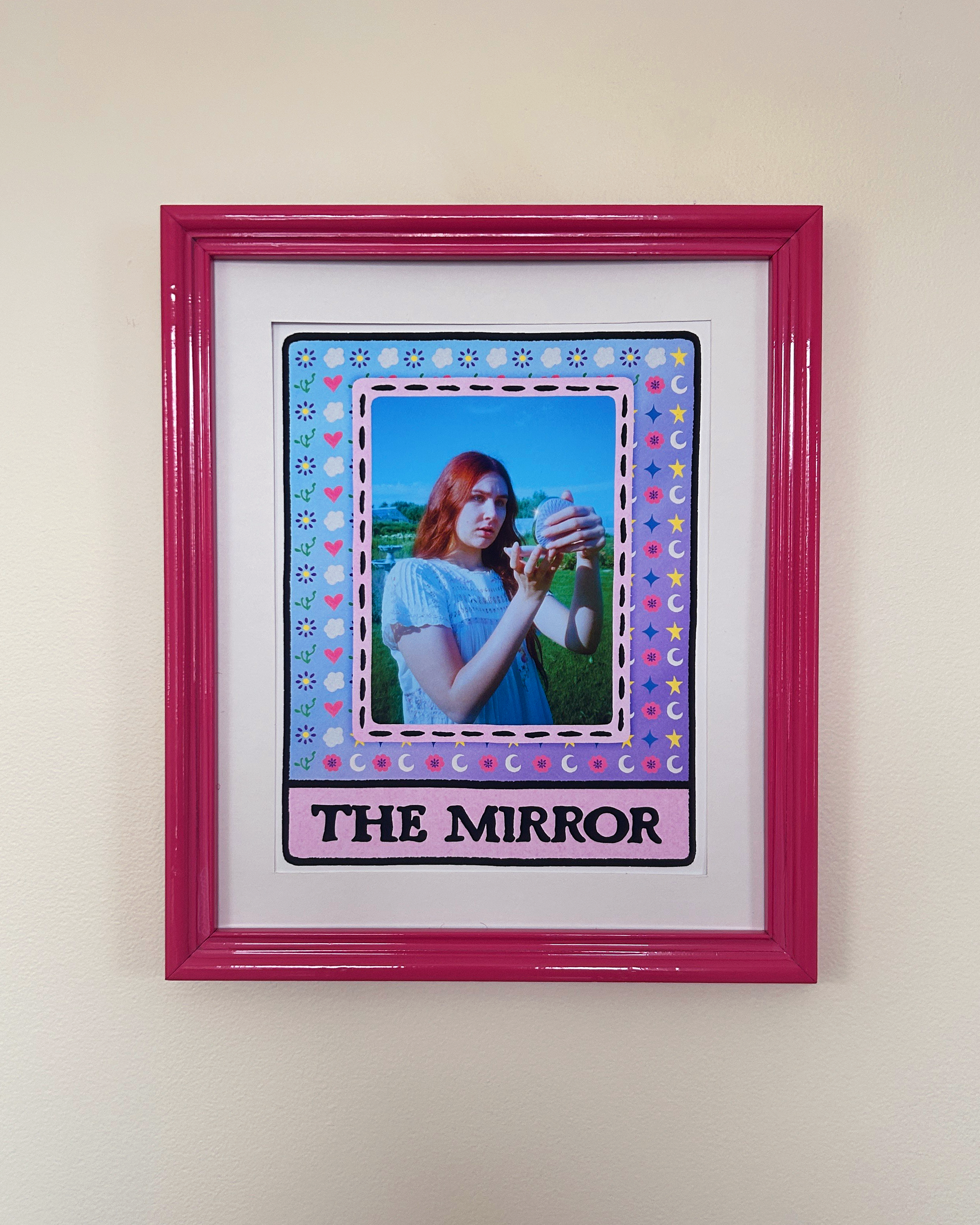 iPhone photo of the print hanging on a wall in daylight