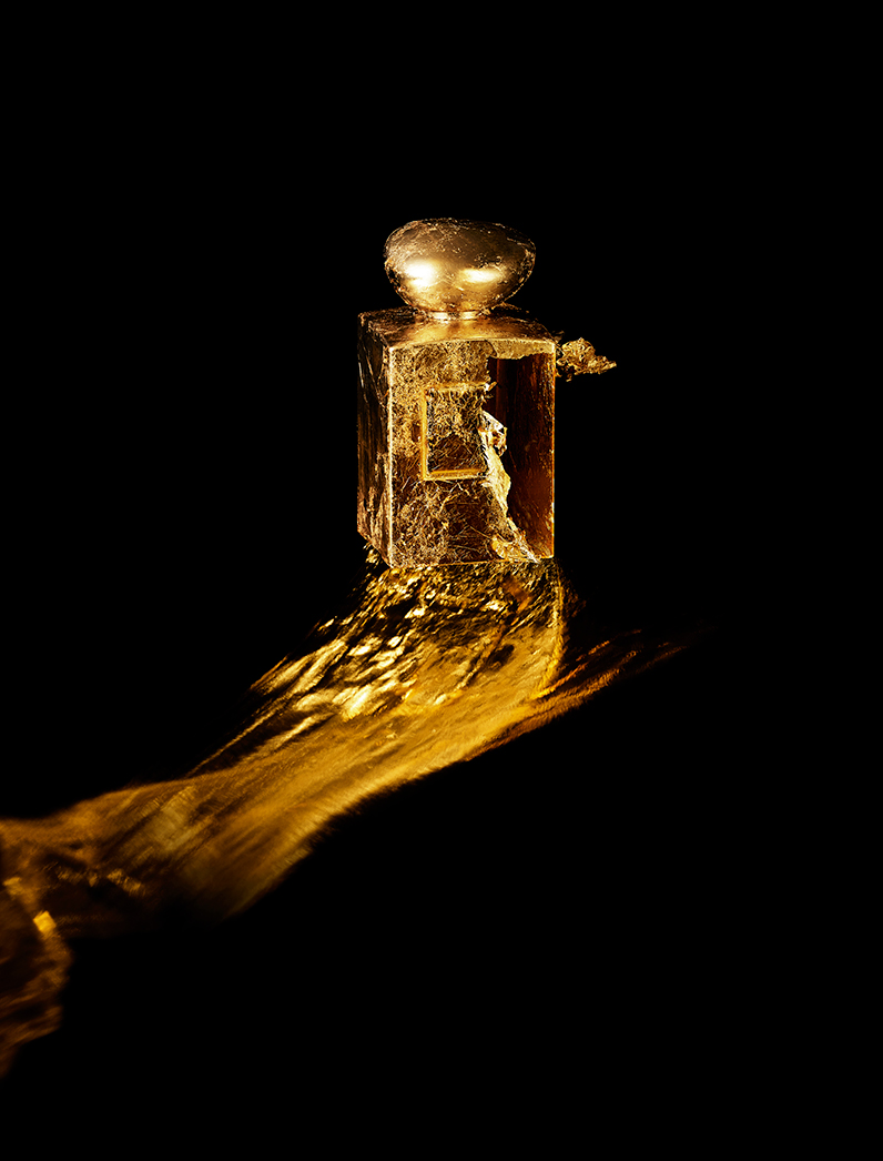 KMA photographer Isabelle Bonjean shoots a close up photograph of a bright gold perfume bottle for Faux Q Magazine 
