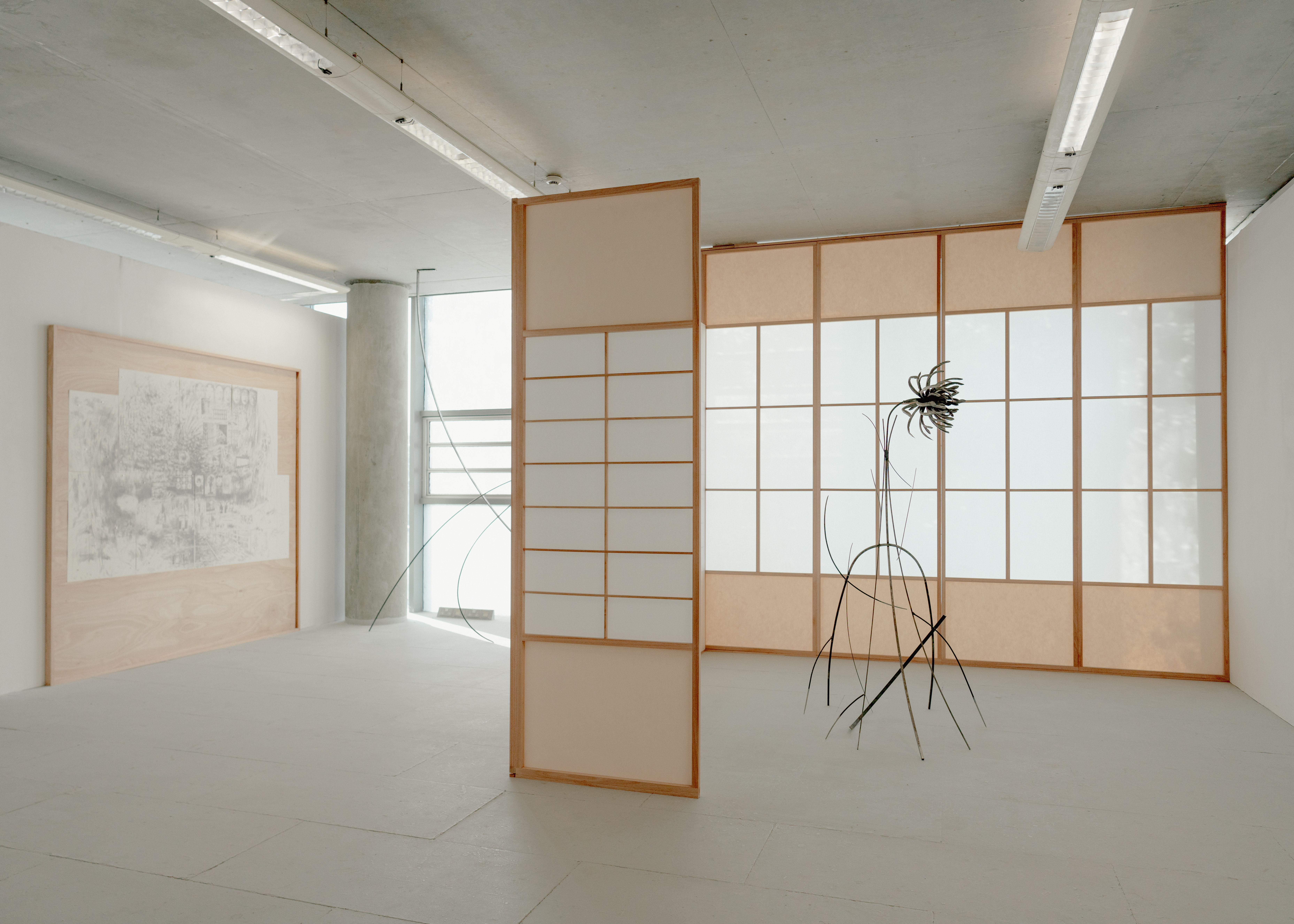 Installation featuring The Nightmare (distant deeps or skies), 2025. Graphite on drawing paper with magnets in plywood and red grandis artist’s frame, Shōji, 2025. Red grandis, shōji paper, rice glue, drawing paper, tape, and Bloom I, 2025. Steel, bronze, trinitite/atomsite glass from Trinity nuclear test site.