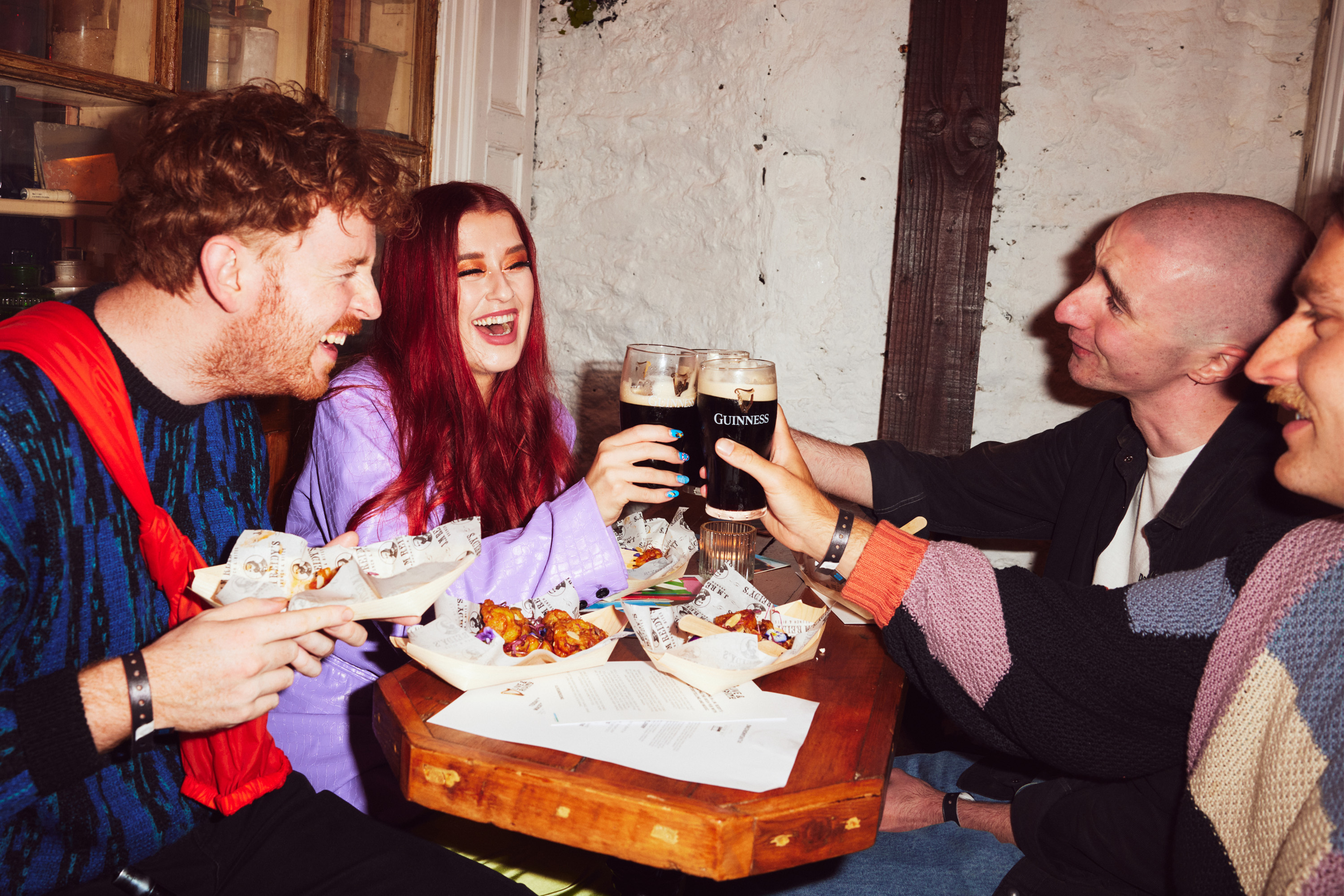 Group of friends in Irish pub drinking Guinness photographed by Dublin based lifestyle, fashion, and advertising photographer Alex Sheridan for Guinness and The Tenth Man, capturing authentic energy and real moments