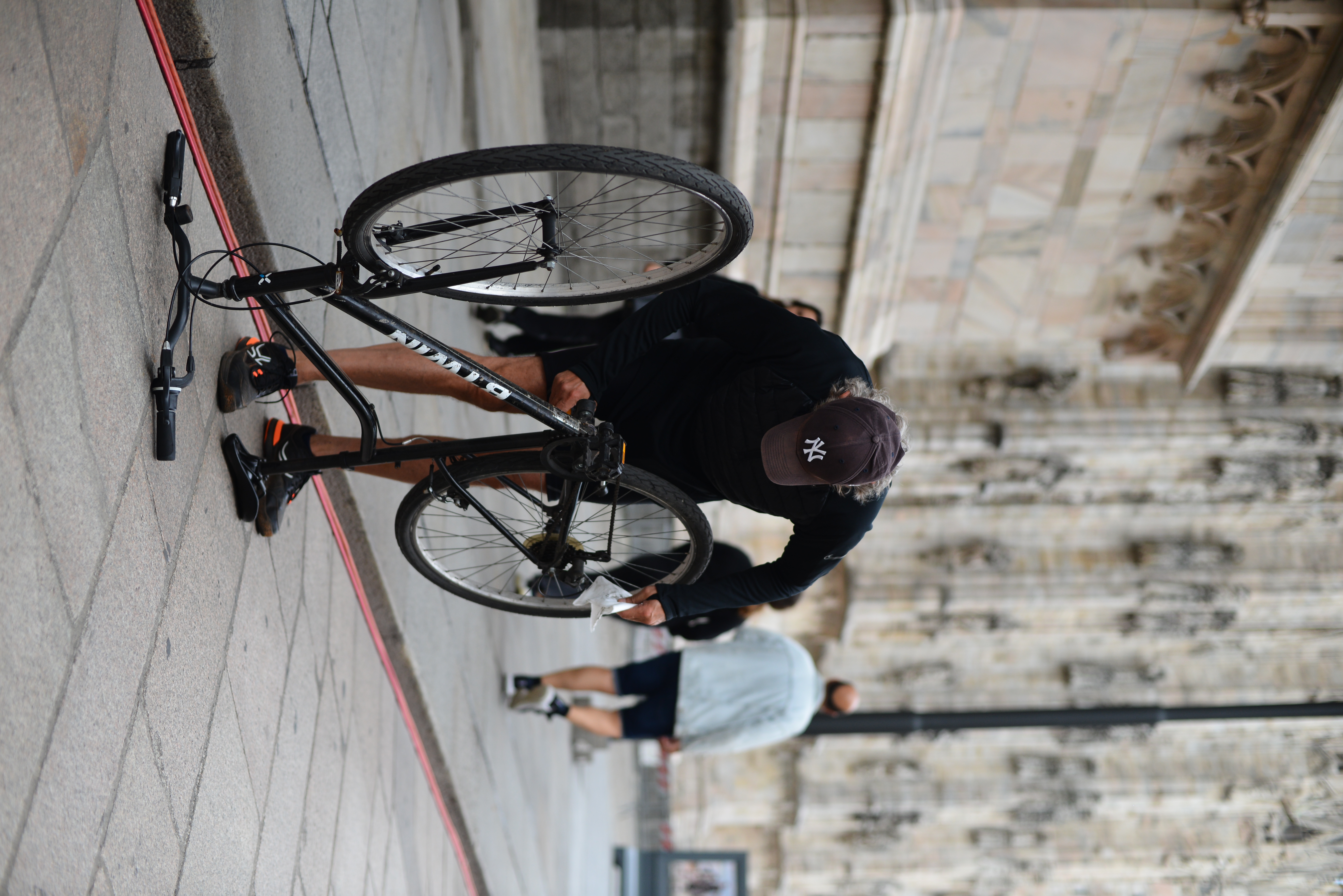 Ciclista aggiusta la catena durante la processione