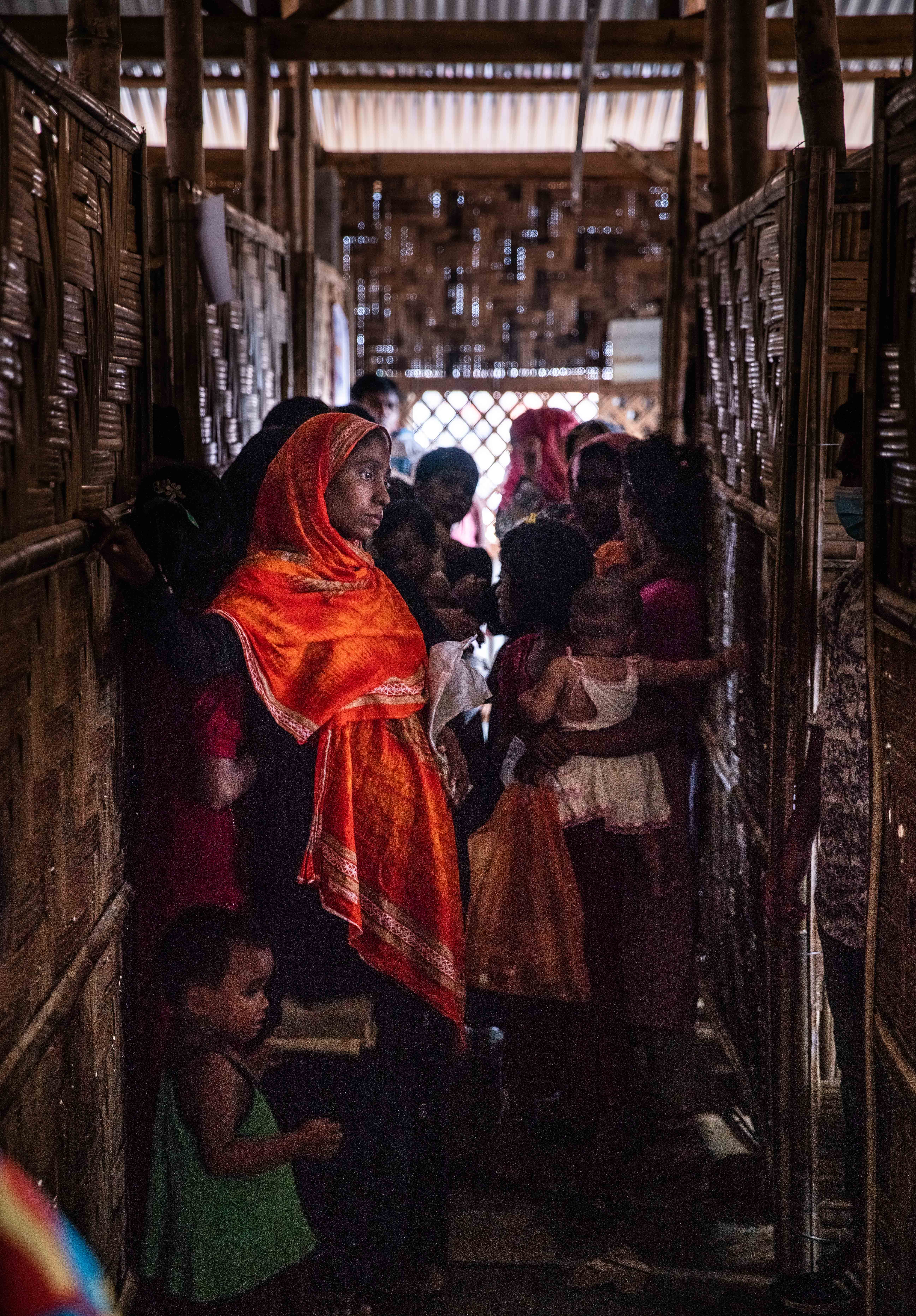 Rohingya women and children wait for their check-ups at a World Vision-run nutrition center in Balukhali refugee camp, Cox’s Bazar district, Bangladesh, on July 30, 2018. With malnutrition still rampant among the refugee population, U.N. agencies and NGOs must distribute approximately 12,200 tons of food supplies each month to almost 900,000 Rohingya spread out over 34 camps.