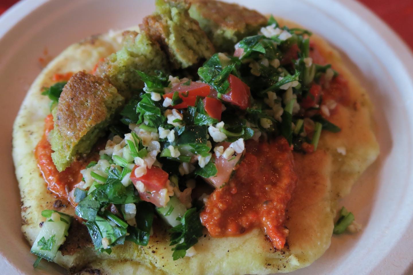 sage and citrus falafel on a fluffy bed of curried pita, dressed with tabbouleh and muhummara