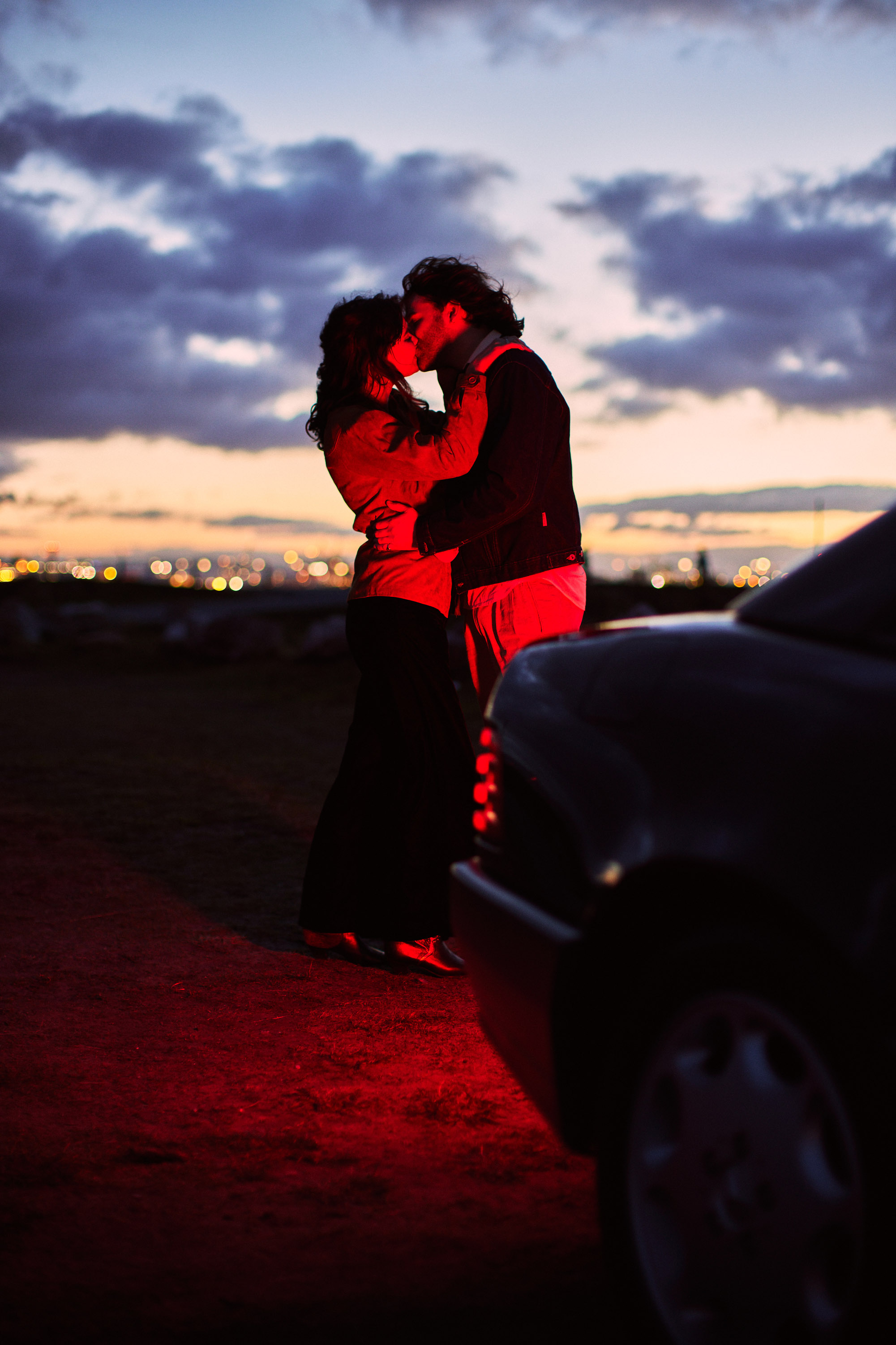 A story of young love in the suburbs told through photography, featuring stylish models in vintage clothing, photographed at sunset in Dublin, Ireland by fashion and lifestyle photographer Alex Sheridan. Suburban Love photo series. Featuring a vintage 1993 Mercedes Benz SL class and cinematic lighting and red light. Euphoria inspired photoshoot.