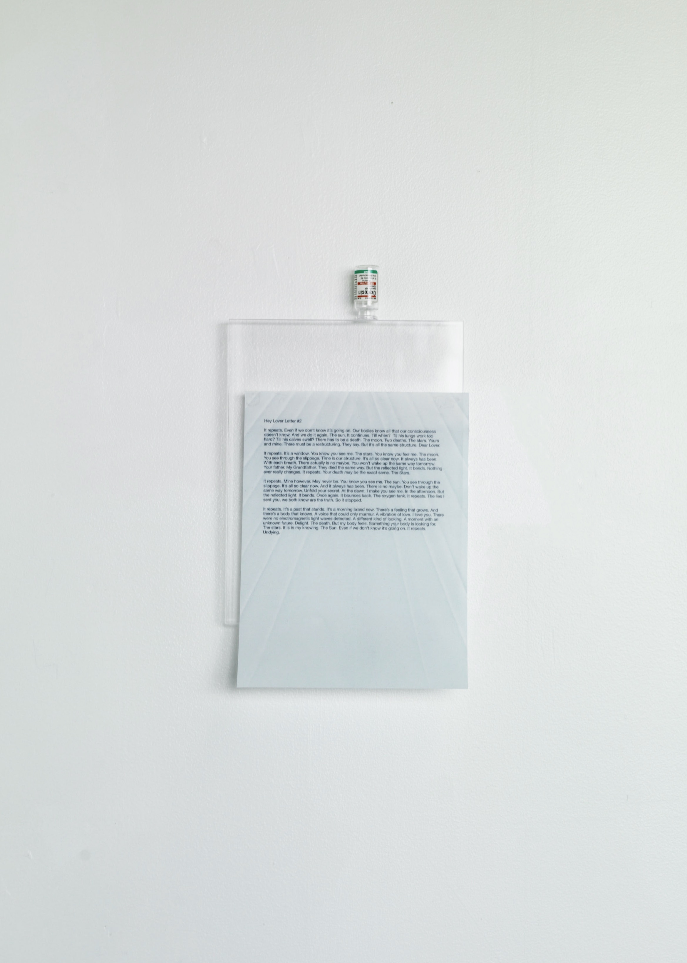 Hey Lover Letter Letter #2, 2019-2021, ink on translucent paper and oxytocin bottle mounted on acrylic glass, approx. 15” x 8 3/4”
