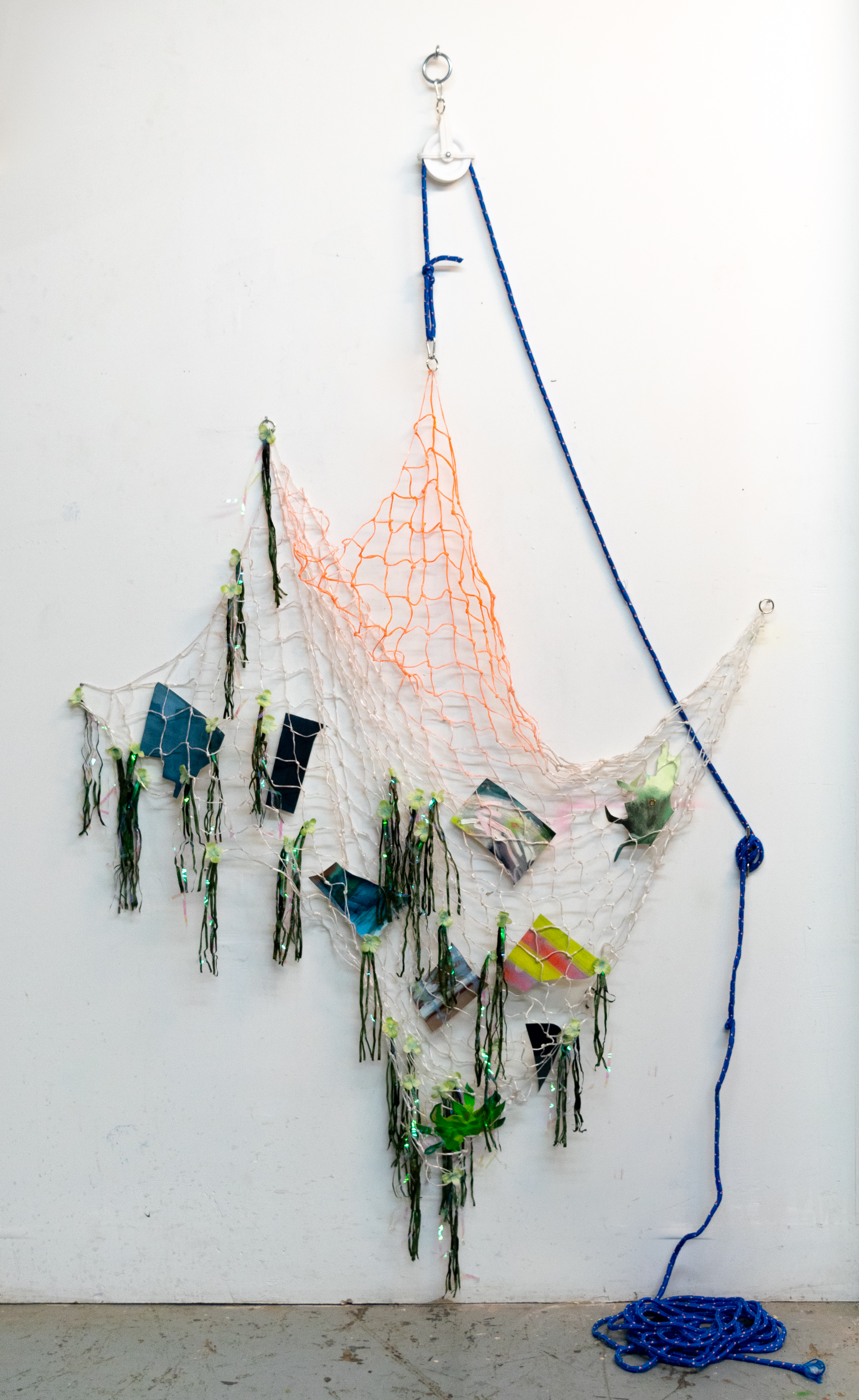 Scrap Net, artificial flowers, carabiners, cut-out painting scraps, hitching ring, holographic streamers, pulley, rope, rope cleat, spray paint, tarp, thread, twine, and welded, rings 96 x 60 x 3 inches, 2020.