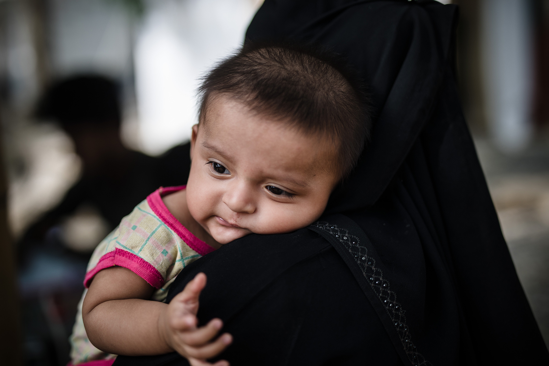 A three months old baby Mohammod, resting on his mother's lap, had high fever and was brought to Red Cross Red Crescent Field Hospital to get treatment.