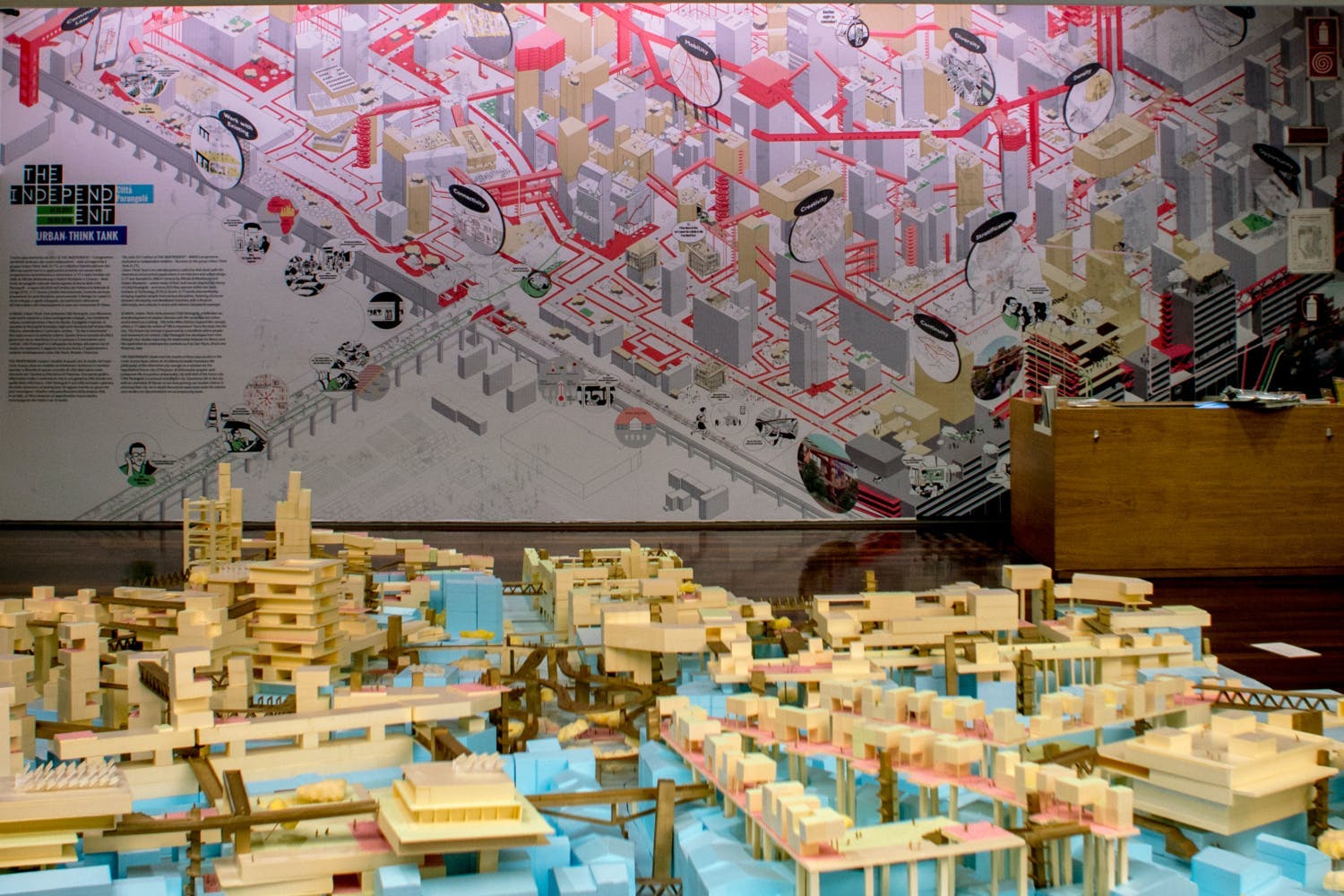 The exhibition wall depicting the utopian city, also reflected in the 6m x 6m model on the floor