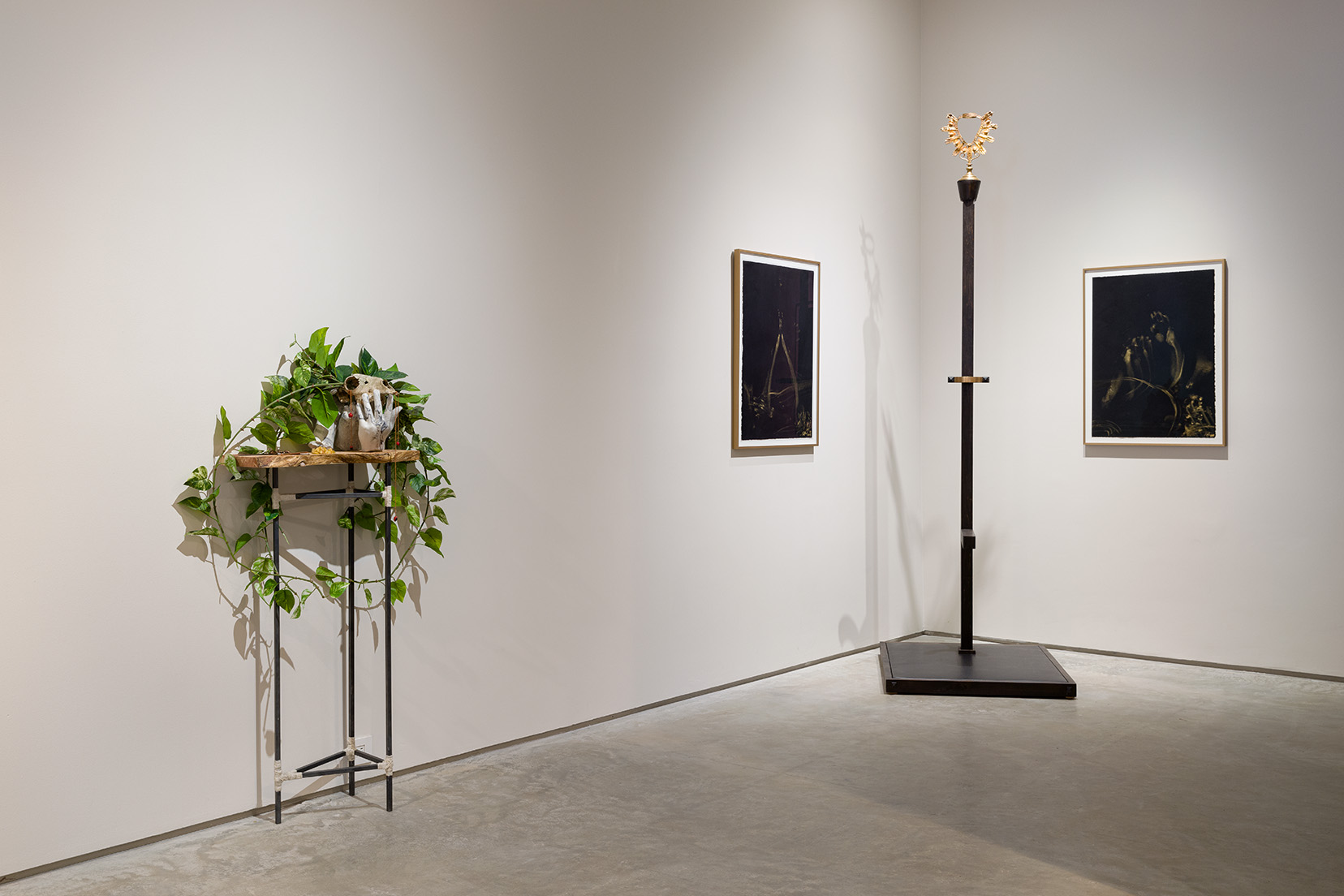 From left to right: Dante Migone-Ojeda, "Amaru," 2023, red cedar, copper, steel, cast stone, alpaca skull, alpaca wool, artificial pothos, Huayruro seeds, medallion, prayer beads, dried yellow potatoes, wax, slag, 54 x 30 x 12 inches; Joseph Liatela, "Consecration," 2022, wood, leather, copper, iron, 1800's Catholic monstrance, 30 x 36 x 97 &frac12; inches. Photo by Etienne Frossard. 